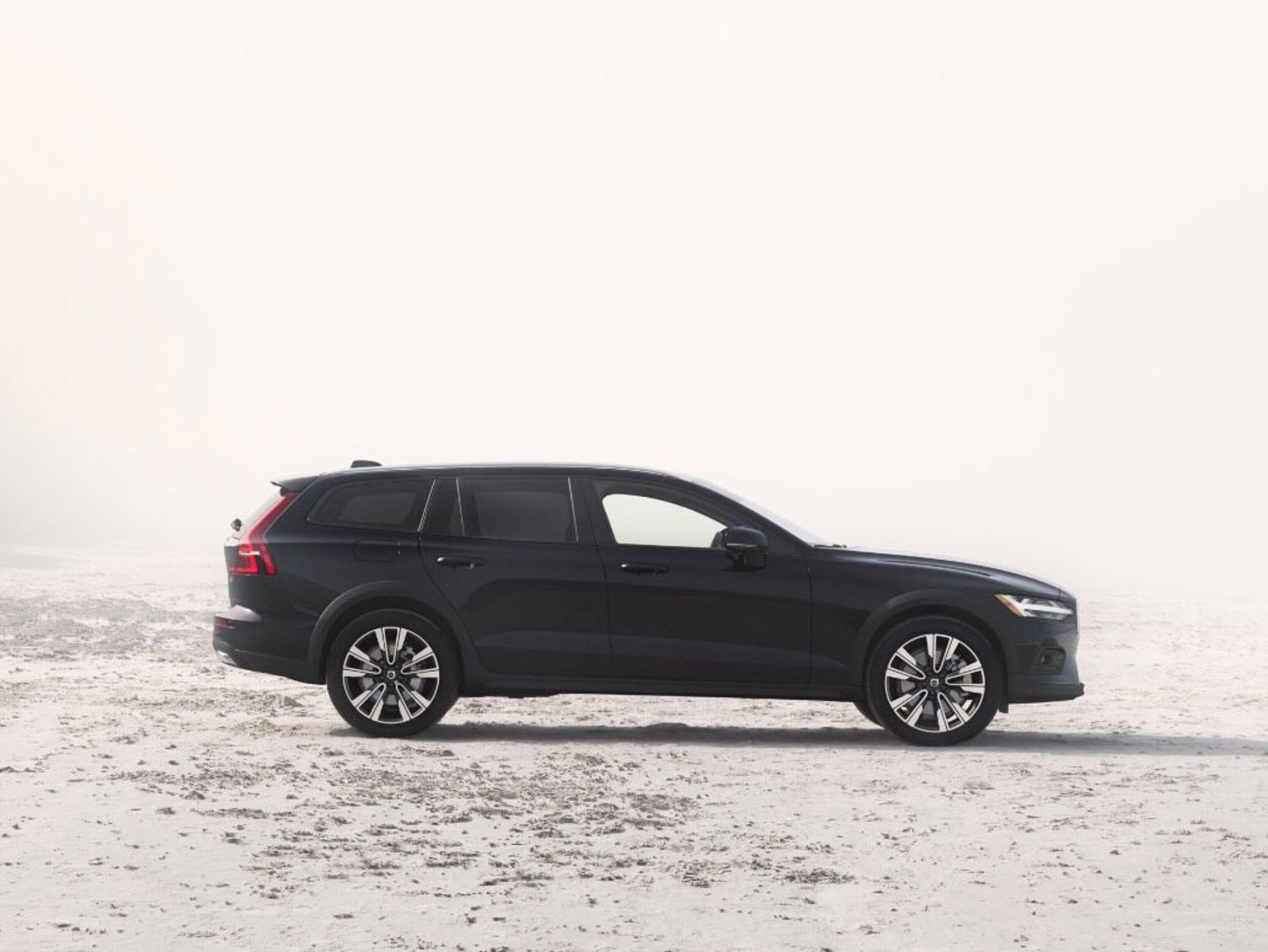 The side profile of a Volvo V60 Cross Country estate with a roof box.