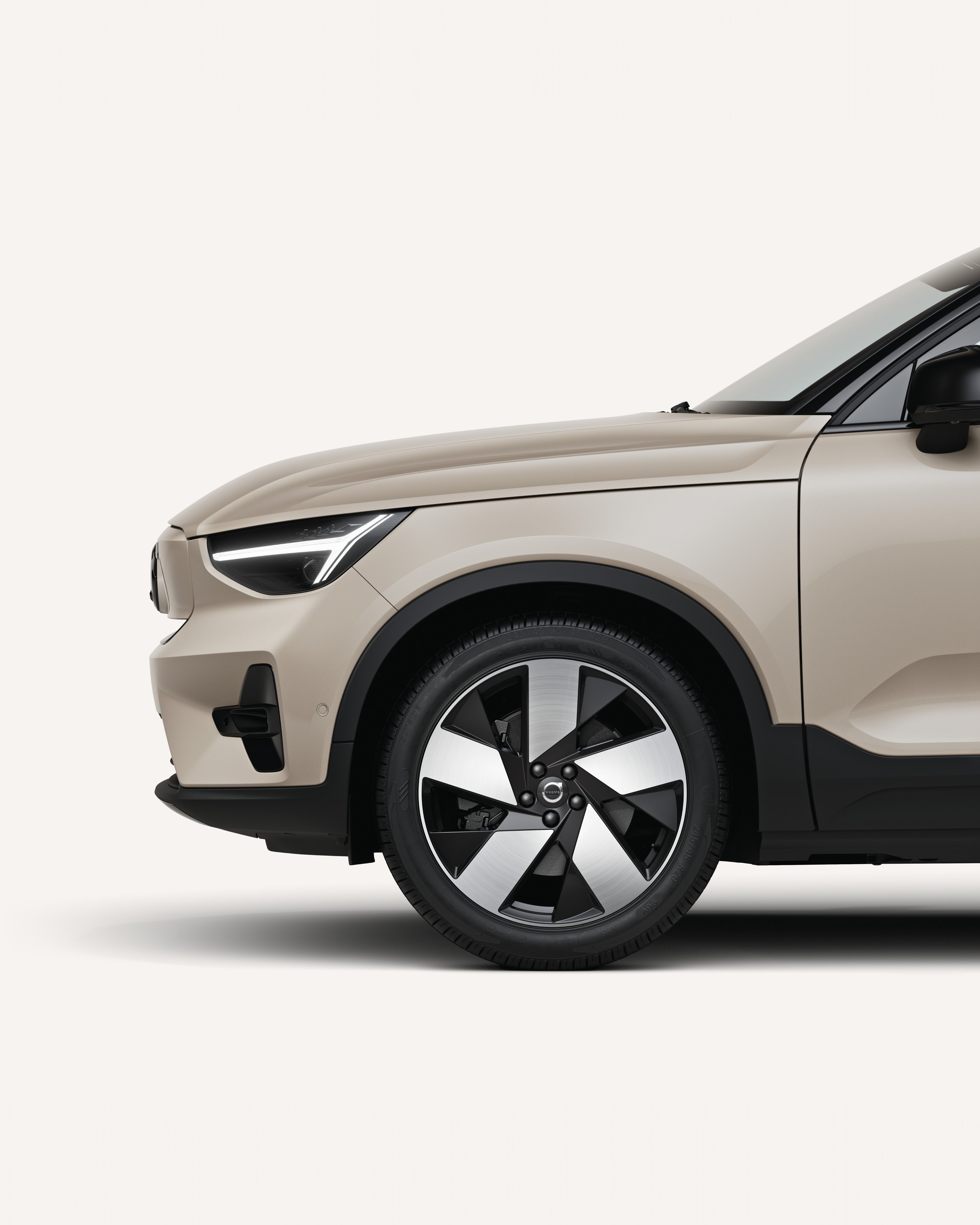Front half of the Volvo EX40 in a white studio environment.