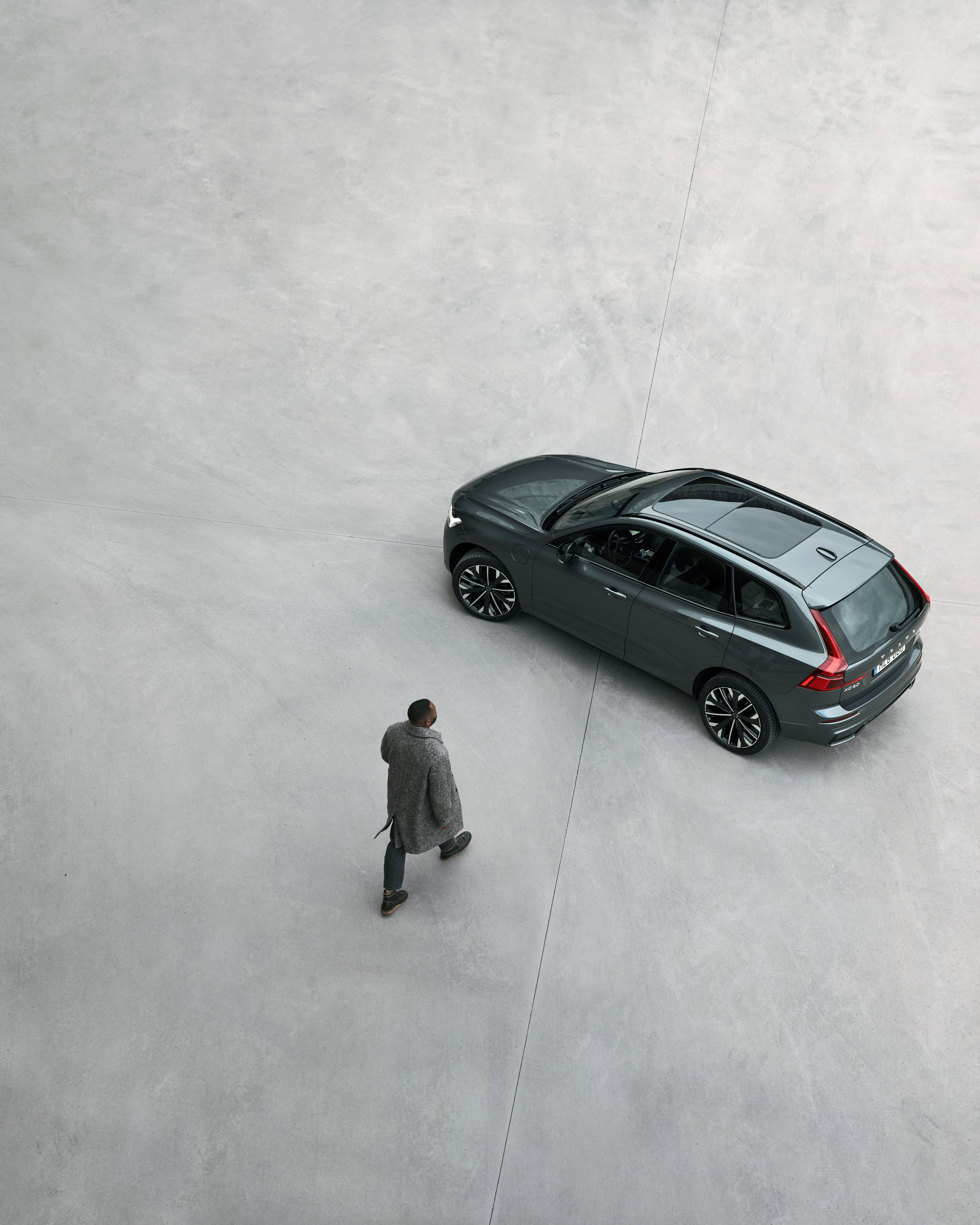 Ein Talent läuft auf einen Volvo XC60 Hybrid zu.