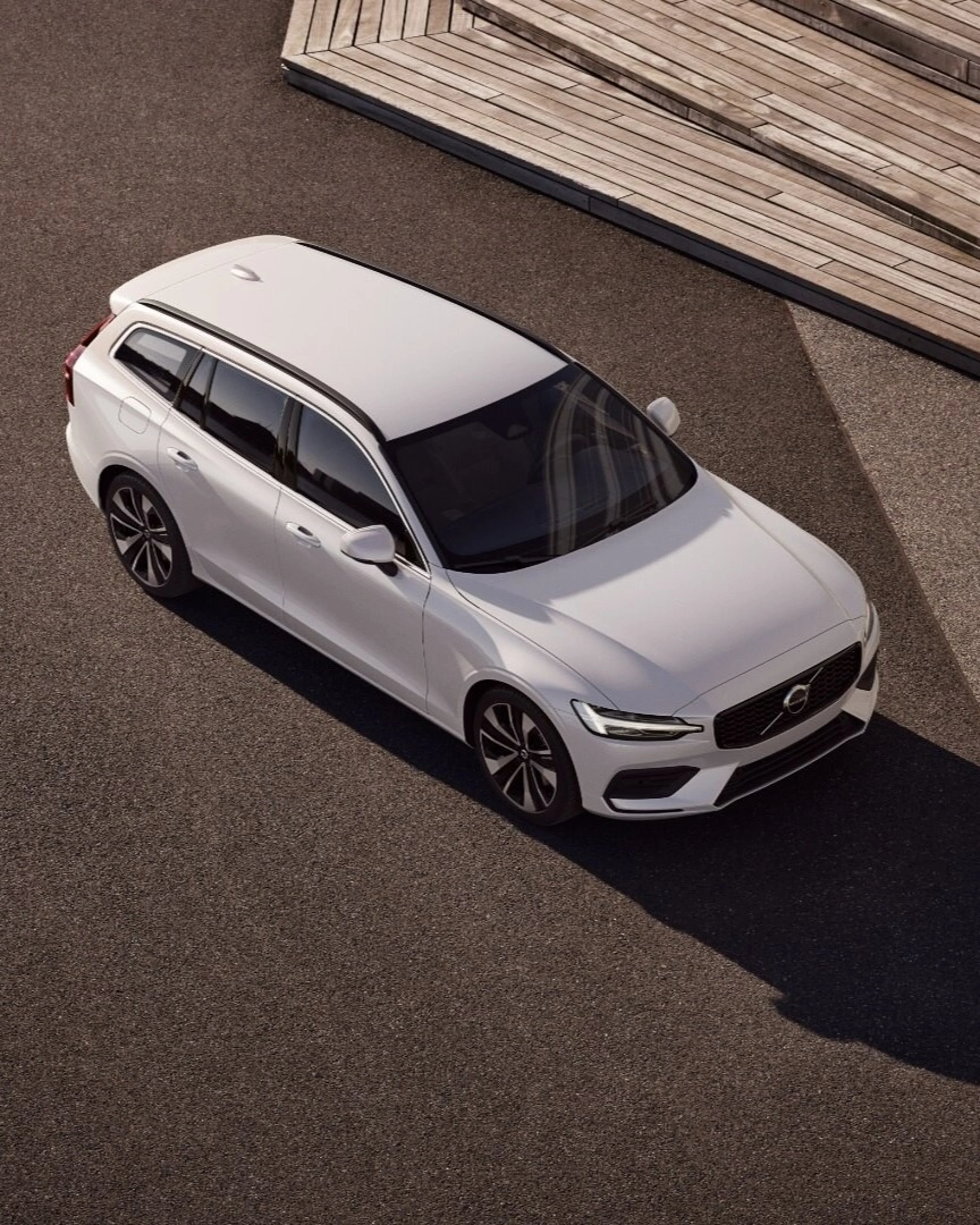 Crystal white värinen Volvo V60 lataushybridifarmariauto yläviistosta kuvattuna.