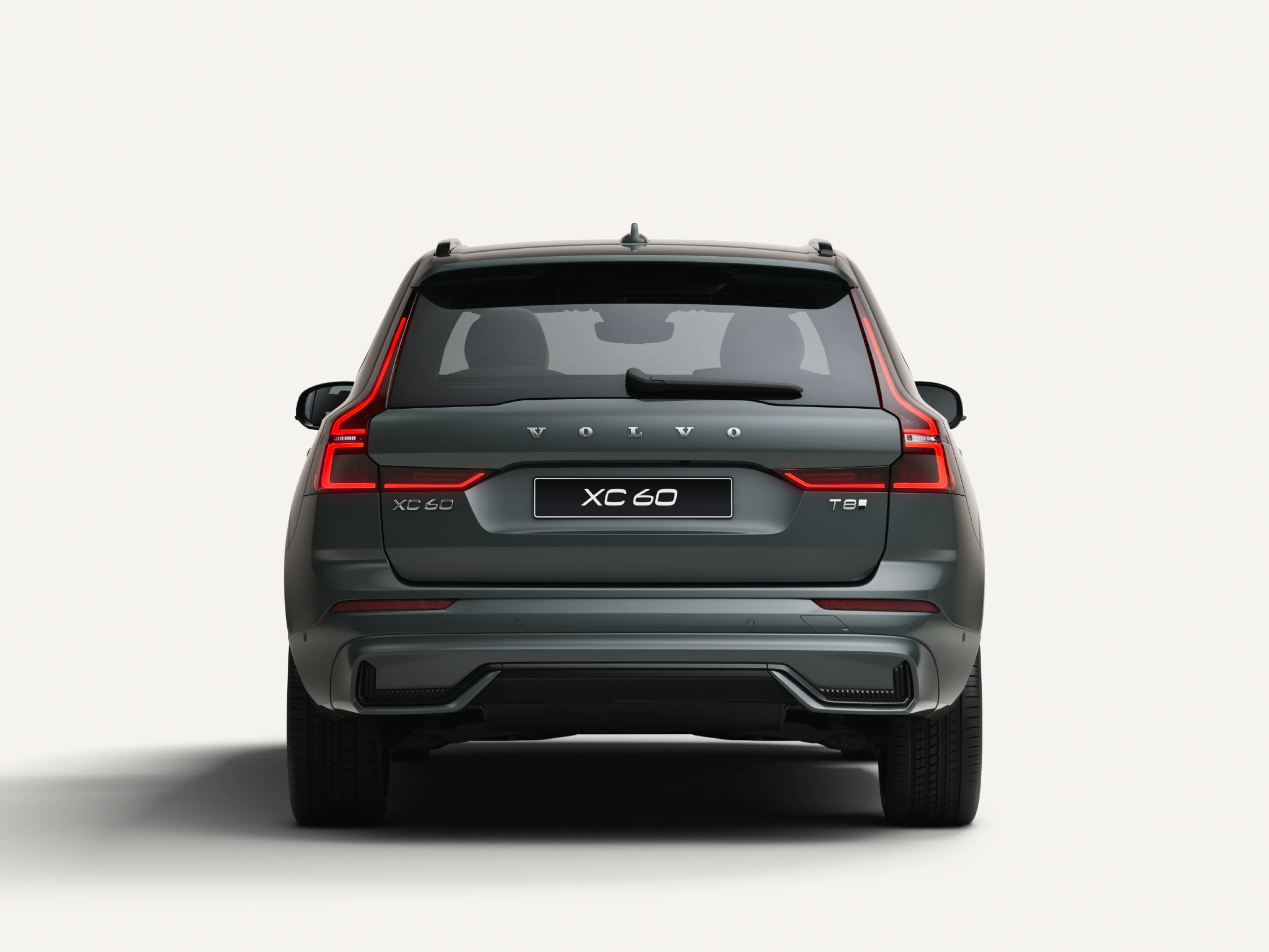 Widok z tyłu średniej wielkości SUV-a Volvo XC60 o napędzie hybrydowym typu Plug-in w białym studiu.