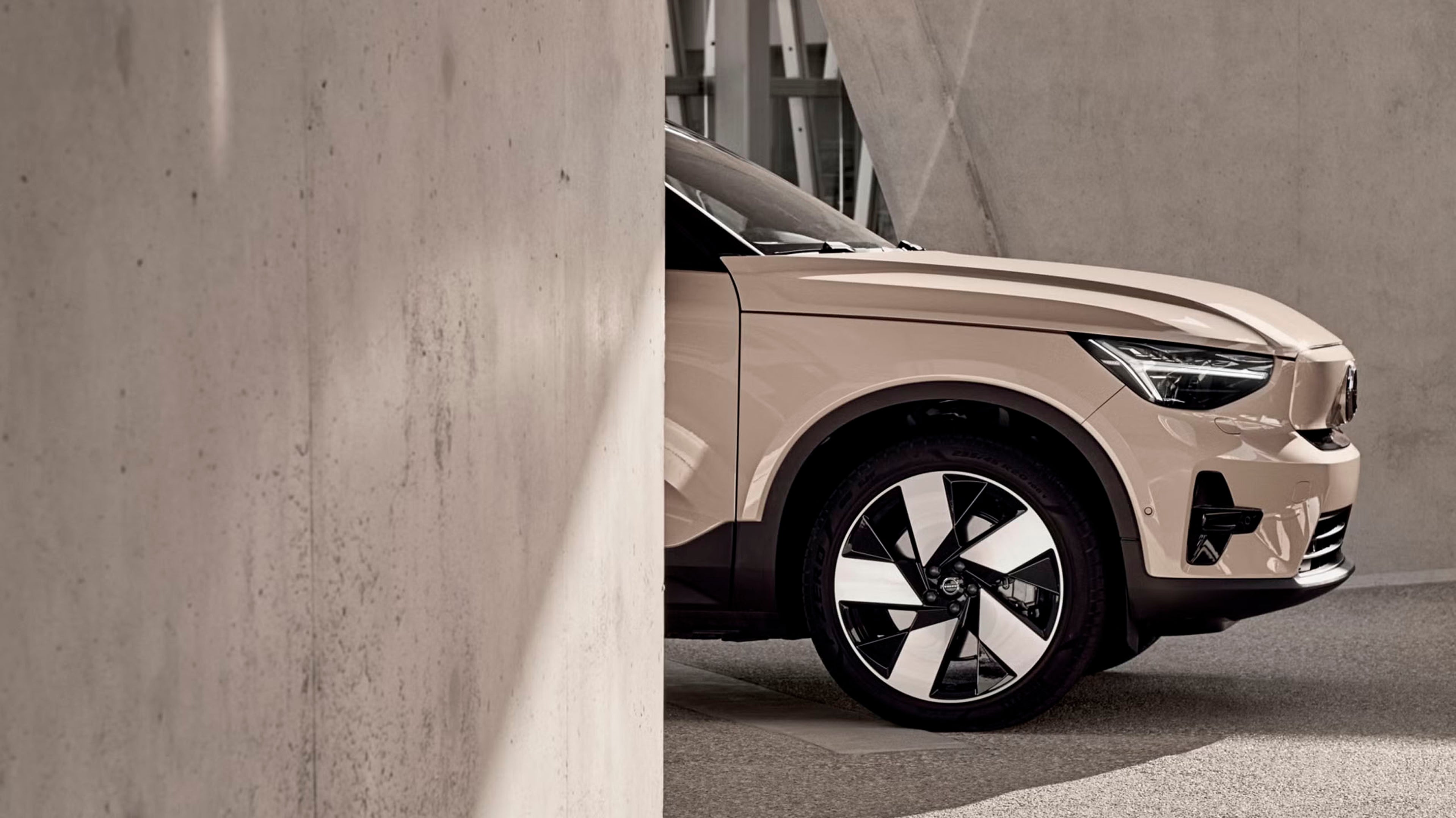 Volvo EX40 eléctrico vista parte frontal destacando los faros LED en color Sand Dust