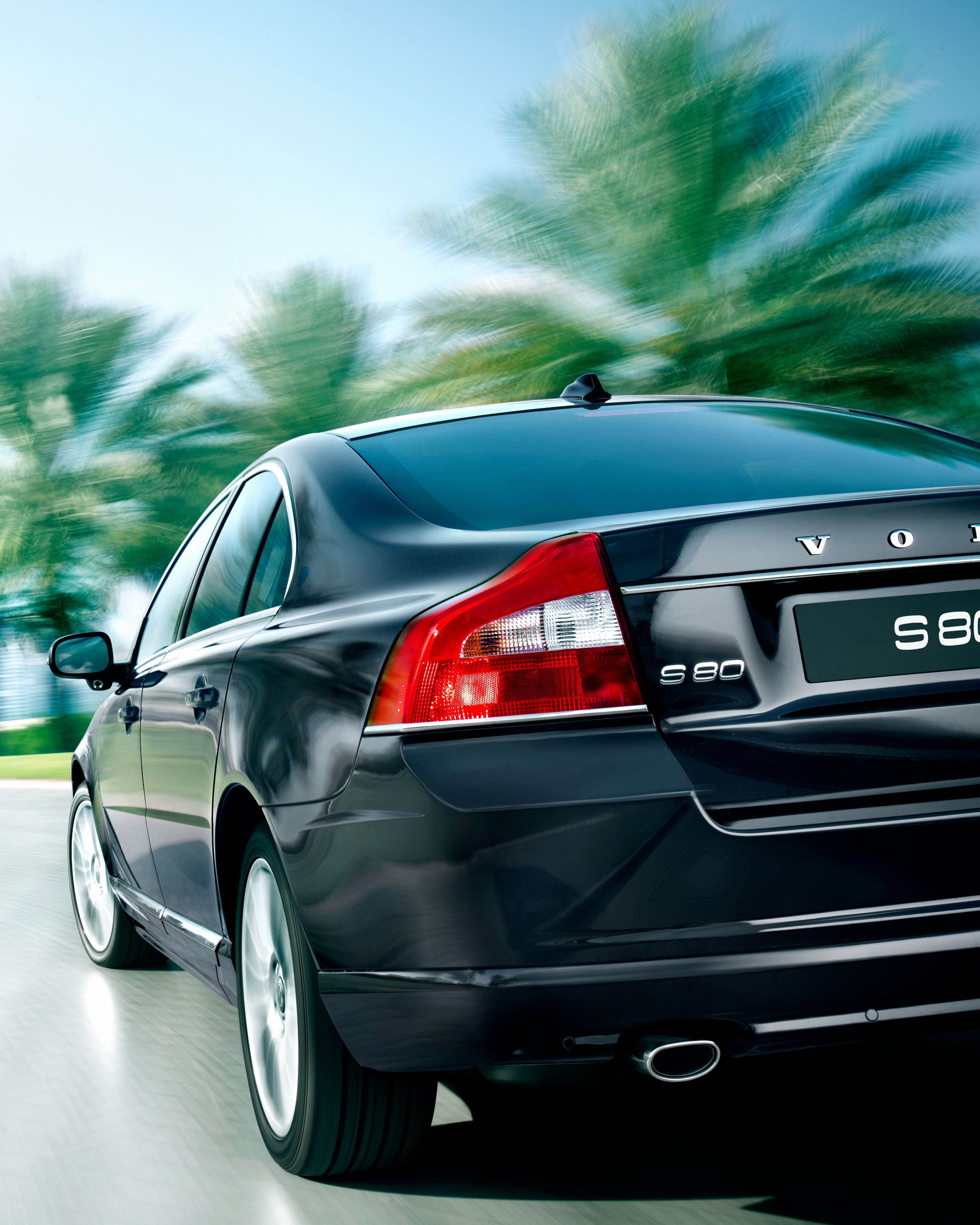 The rear of a Volvo S80 driving along a road.