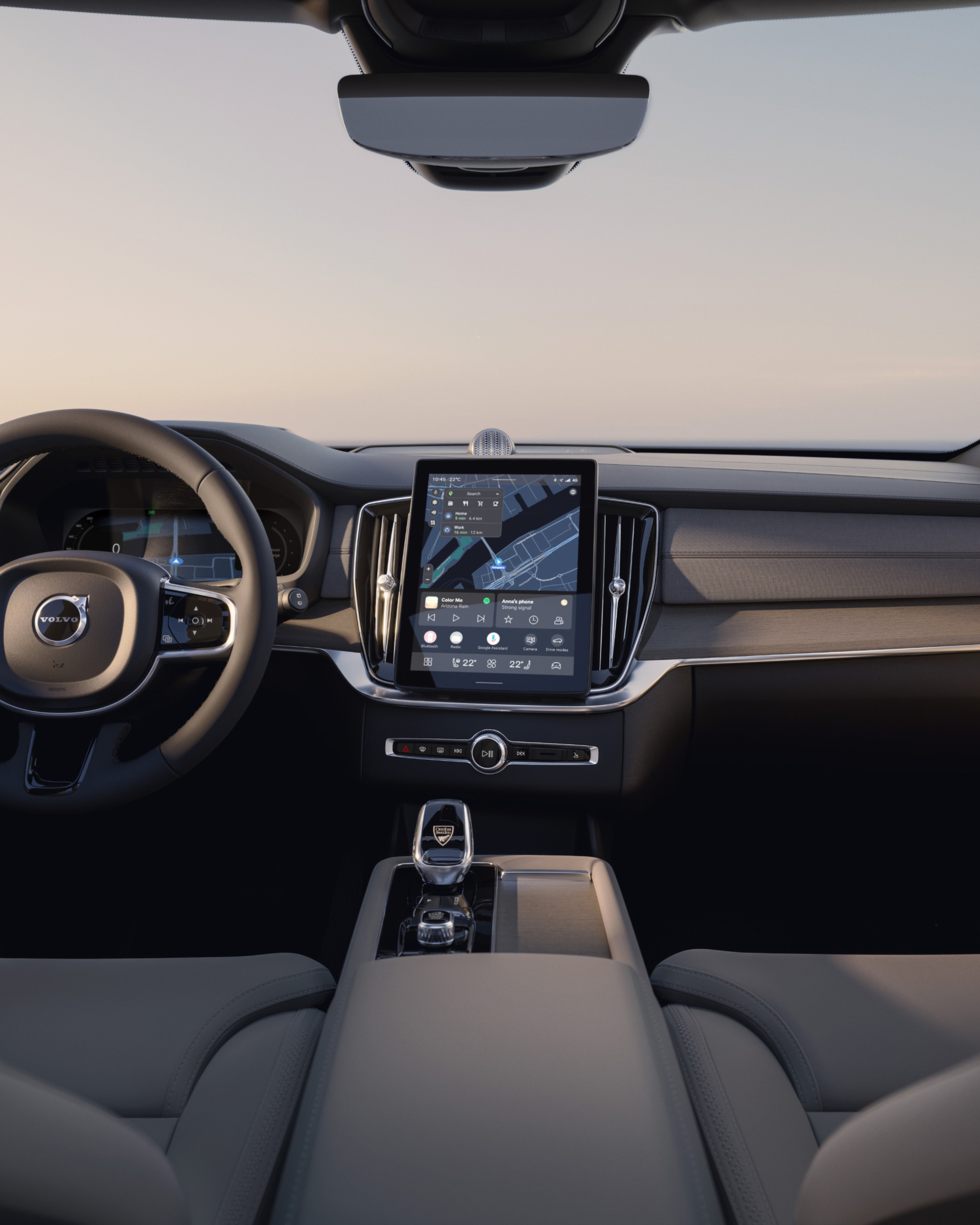 Vue du tableau de bord du Volvo XC90 depuis la banquette arrière, y compris le volant et l’écran tactile.