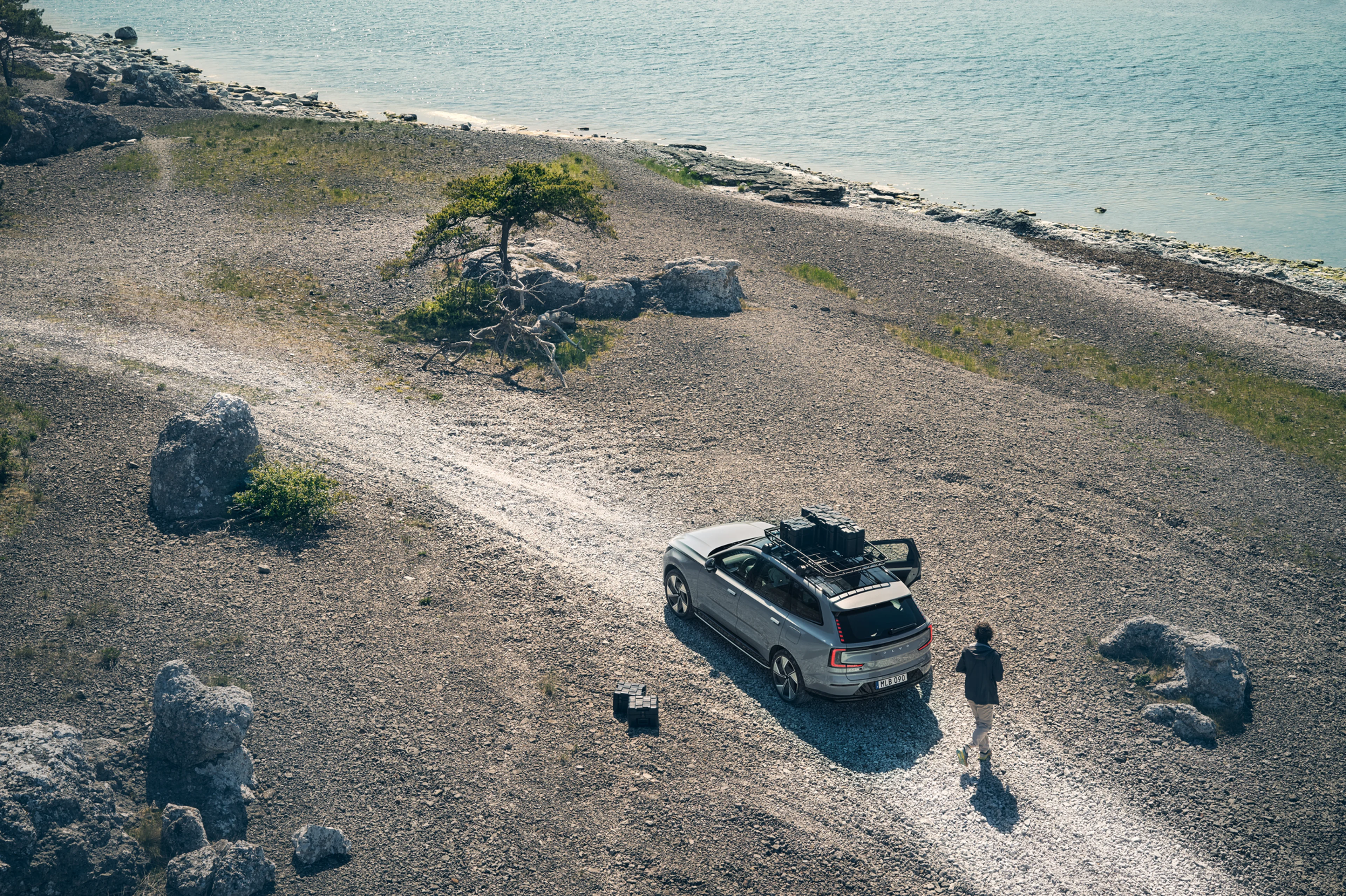Volvo parkiran na makadamskoj cesti s teretom sigurno ukrcanim na krov automobila.