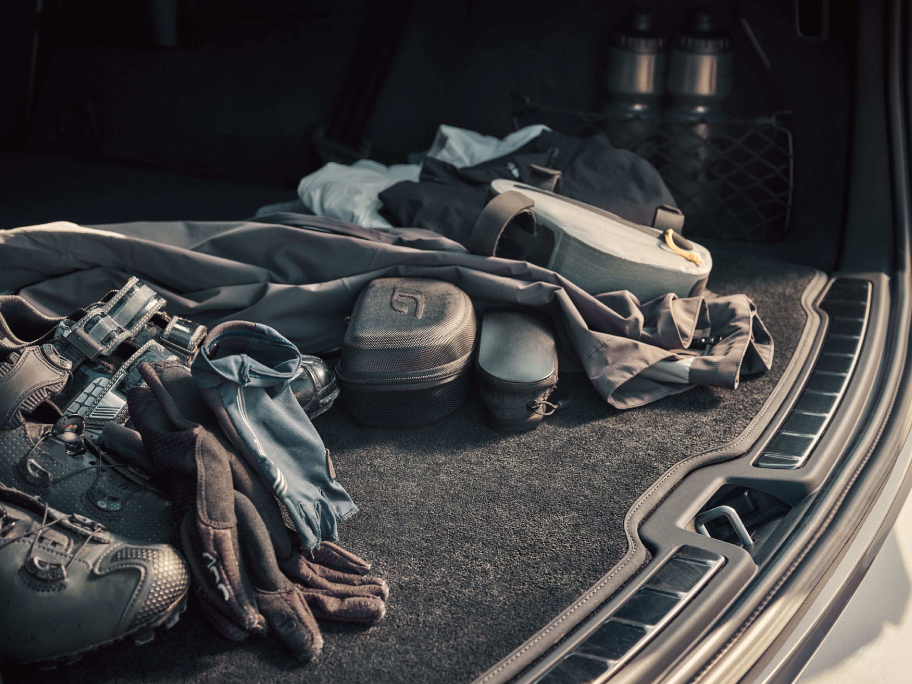 一堆物品放置在行李箱地墊上。
