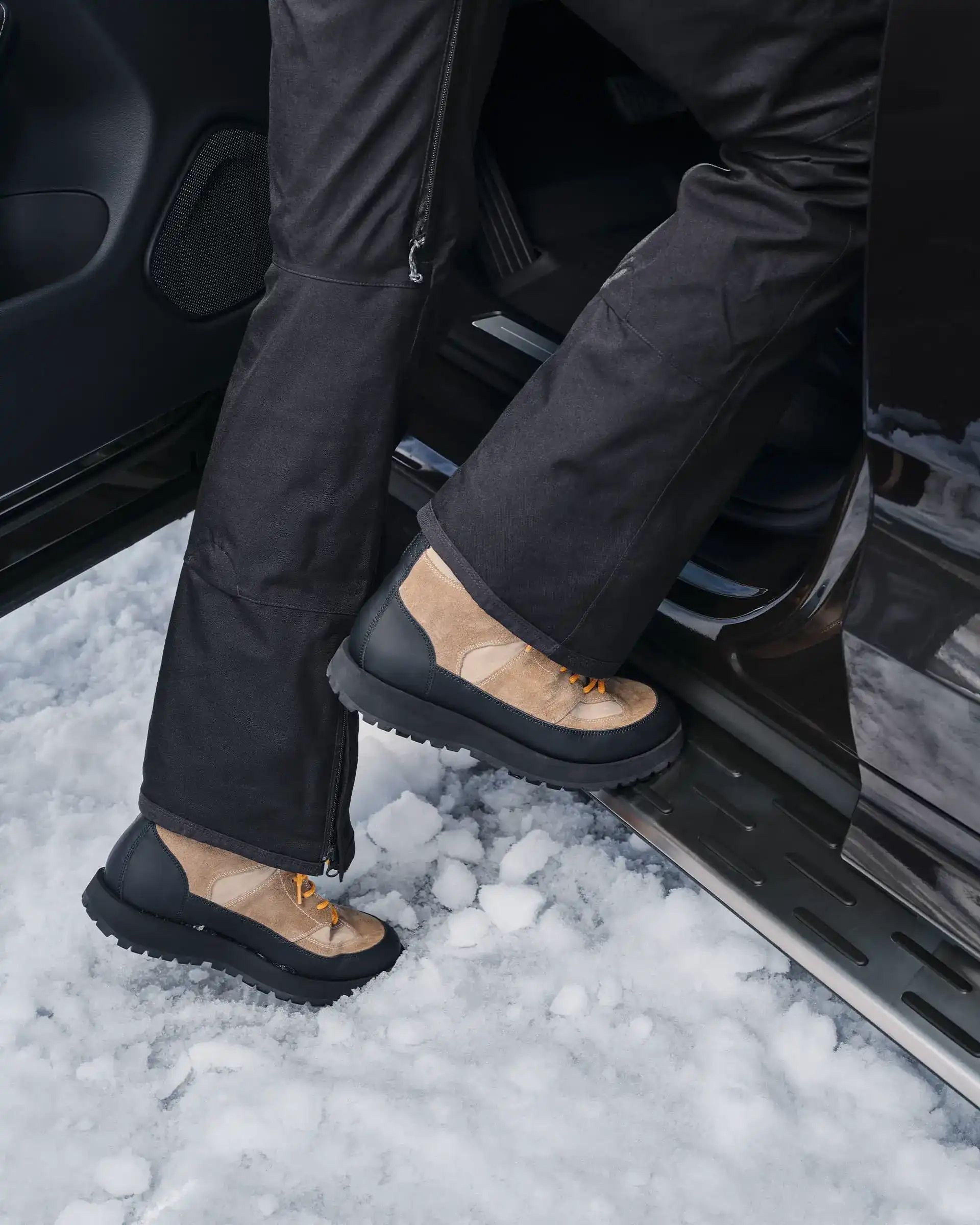 Egy ember hótaposóban, amint egy Volvo küszöbfellépőjére lép.