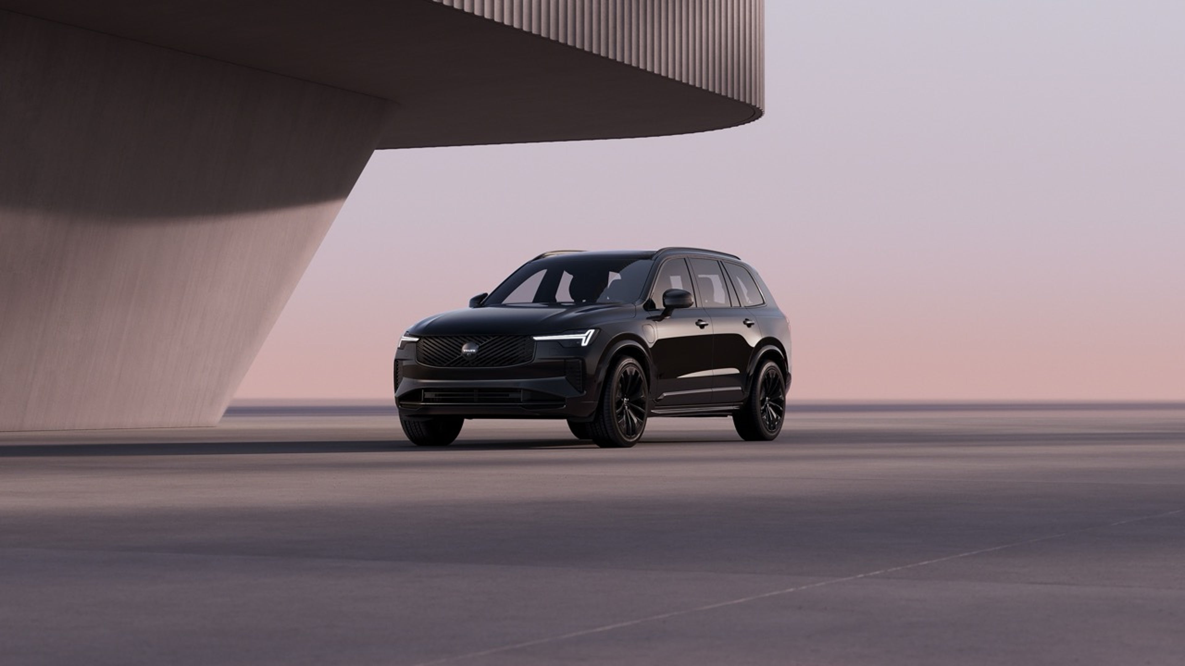 Një XC90 krejtësisht i zi Black Edition i parkuar në perëndim të diellit.