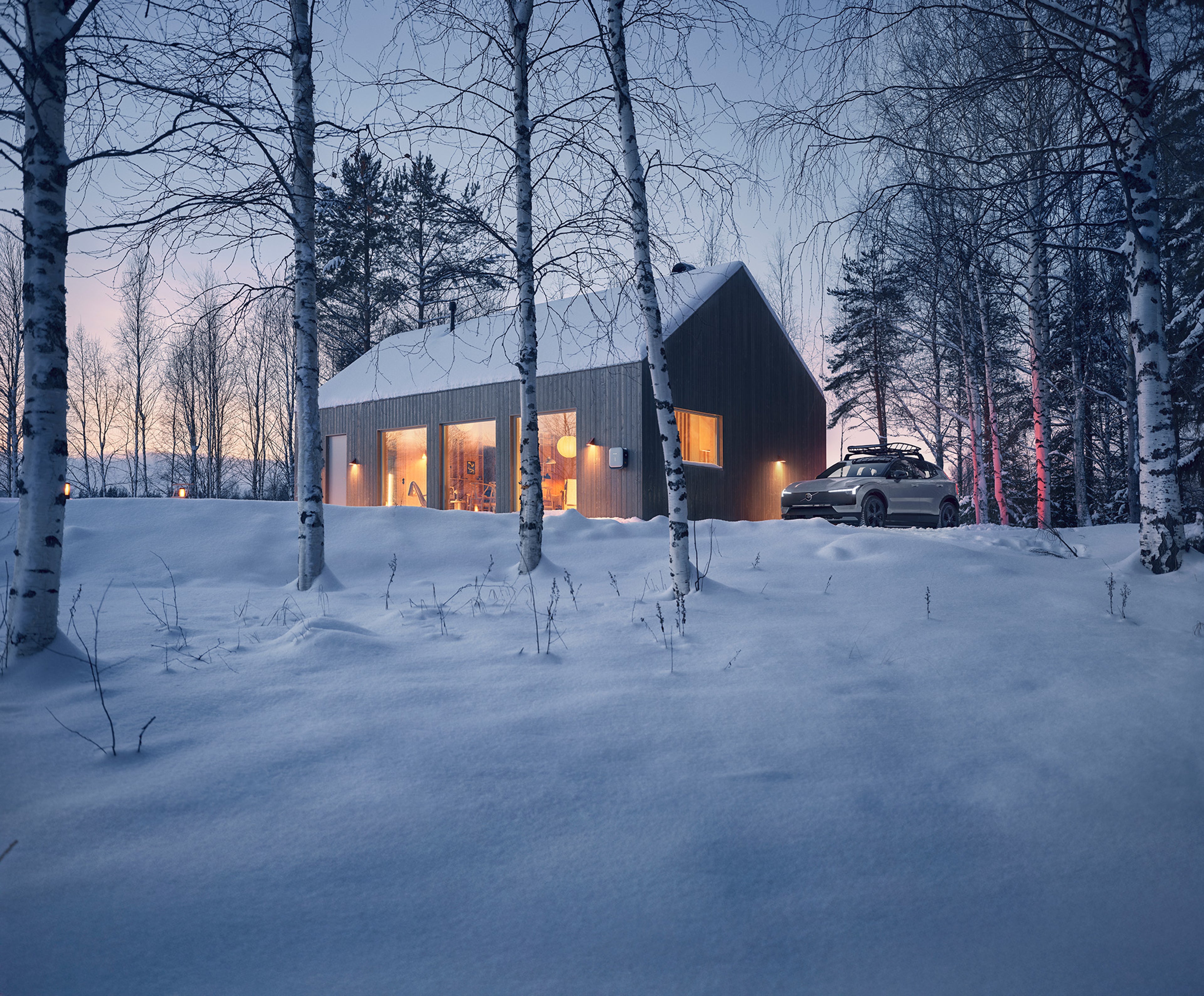 Volvo EX30 Cross Country in front of a secluded cabin, highlighting its durable all-wheel drive system and rugged design elements.