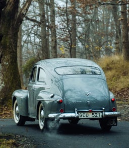 صورة من الخلف لـVolvo PV444 الكلاسيكية تعرض صندوقها الخلفي الدائري الشهير وأضواءها الخلفية.