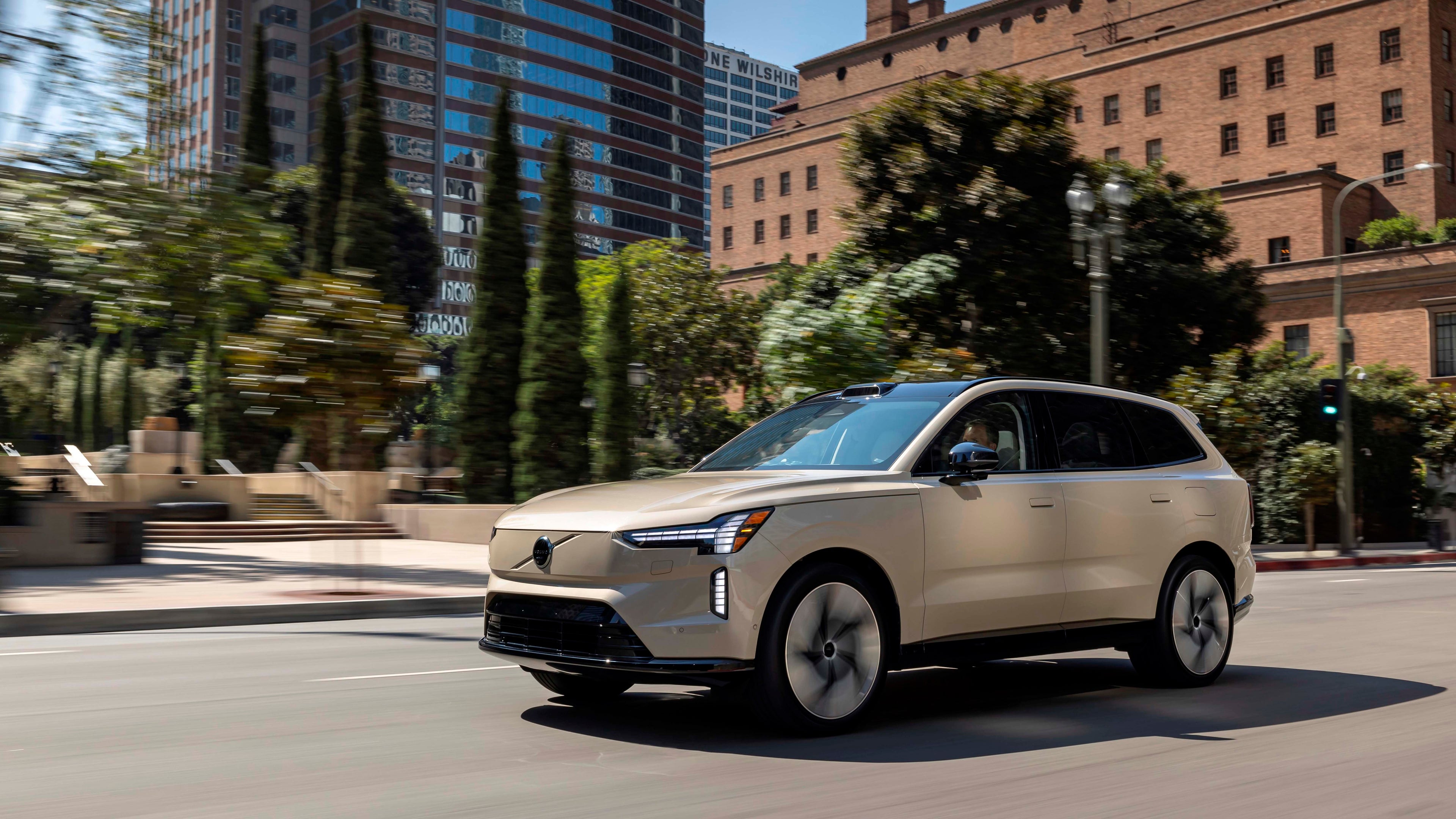 Volvo EX90 rodeado de edificios atravesando una calle de la ciudad