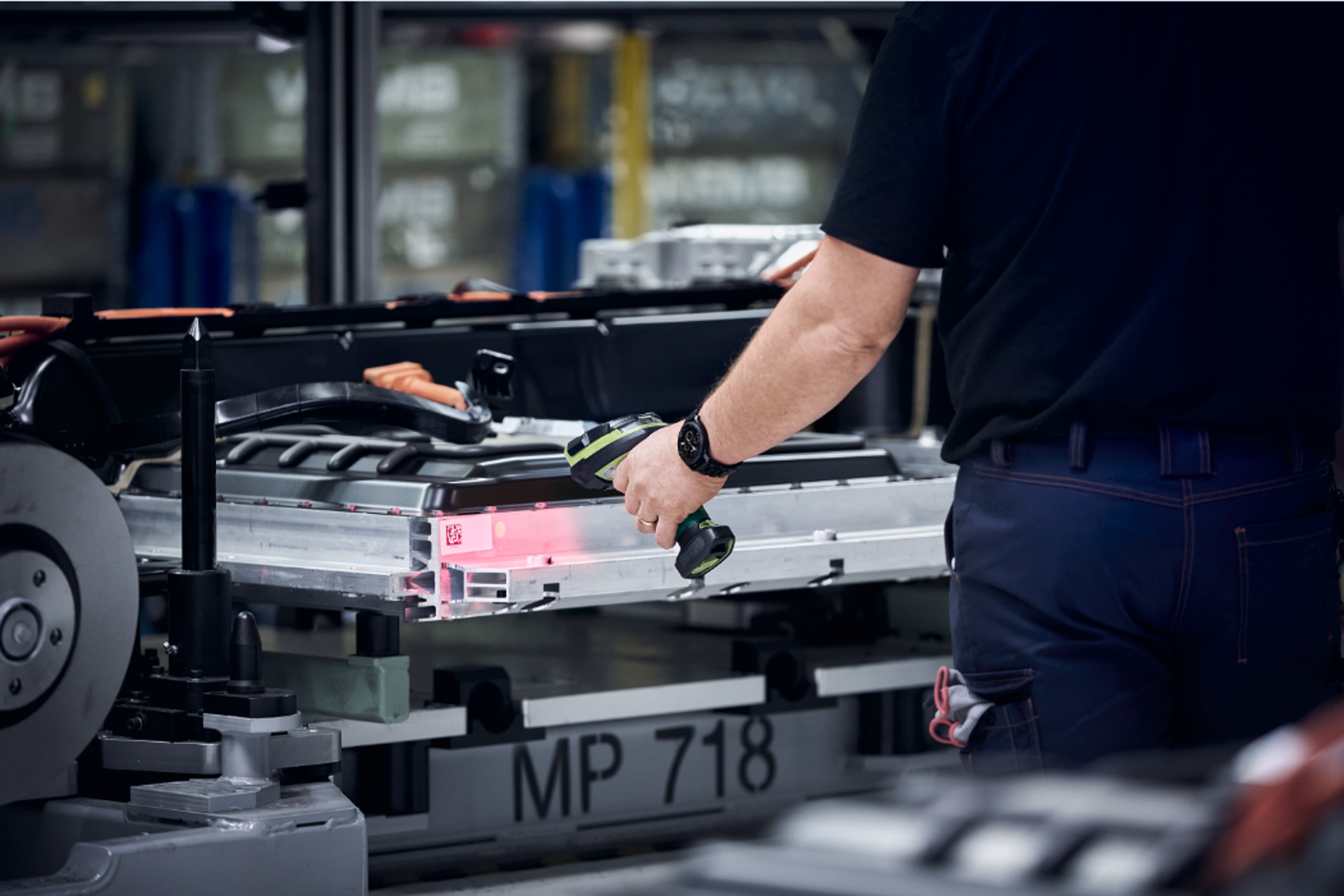 A Volvo Cars factory worker scanning a QR code on a car part.