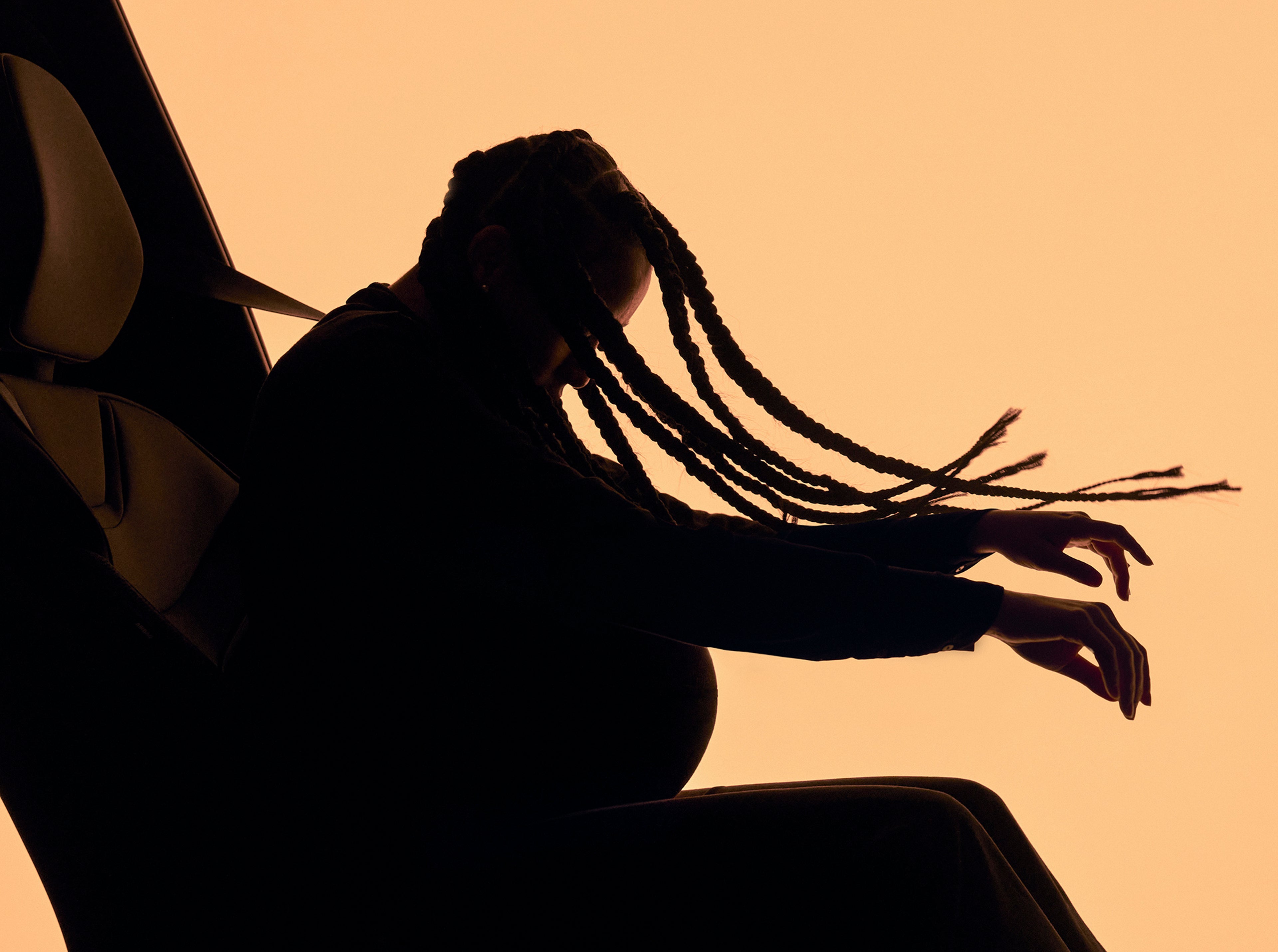 Sagoma di una donna incinta con i capelli intrecciati che subisce il movimento simulato di un impatto all'interno di un'auto, mettendo in mostra la tecnologia delle cinture di sicurezza multiadattive di Volvo Cars, progettata per proteggere diversi tipi di corporatura.