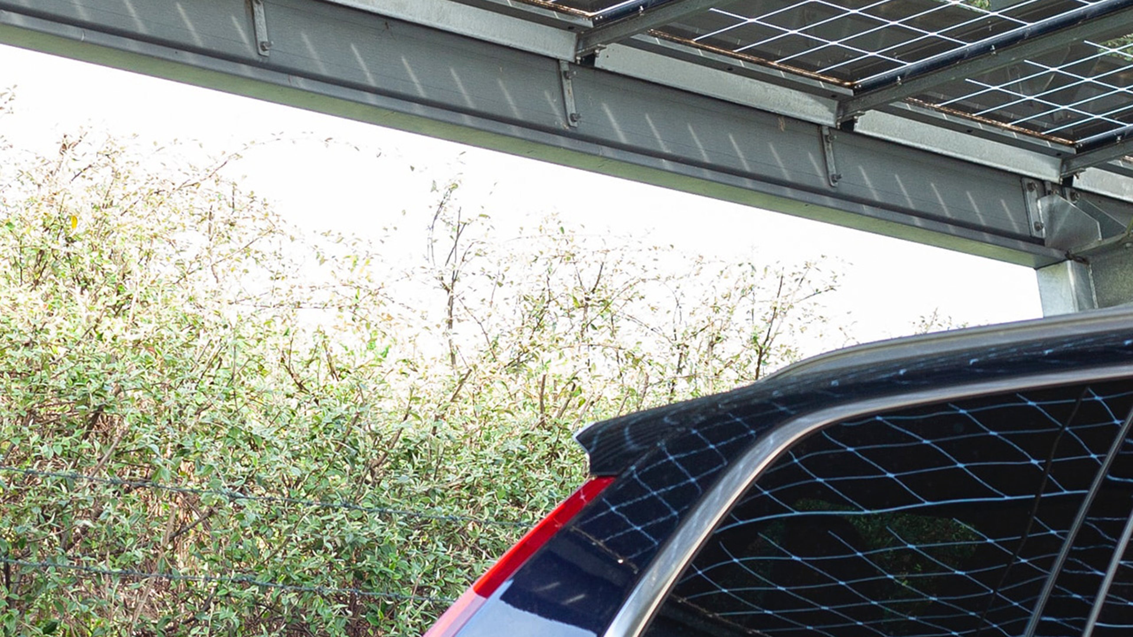 Des panneaux solaires se reflètent dans la vitre d'une Volvo.