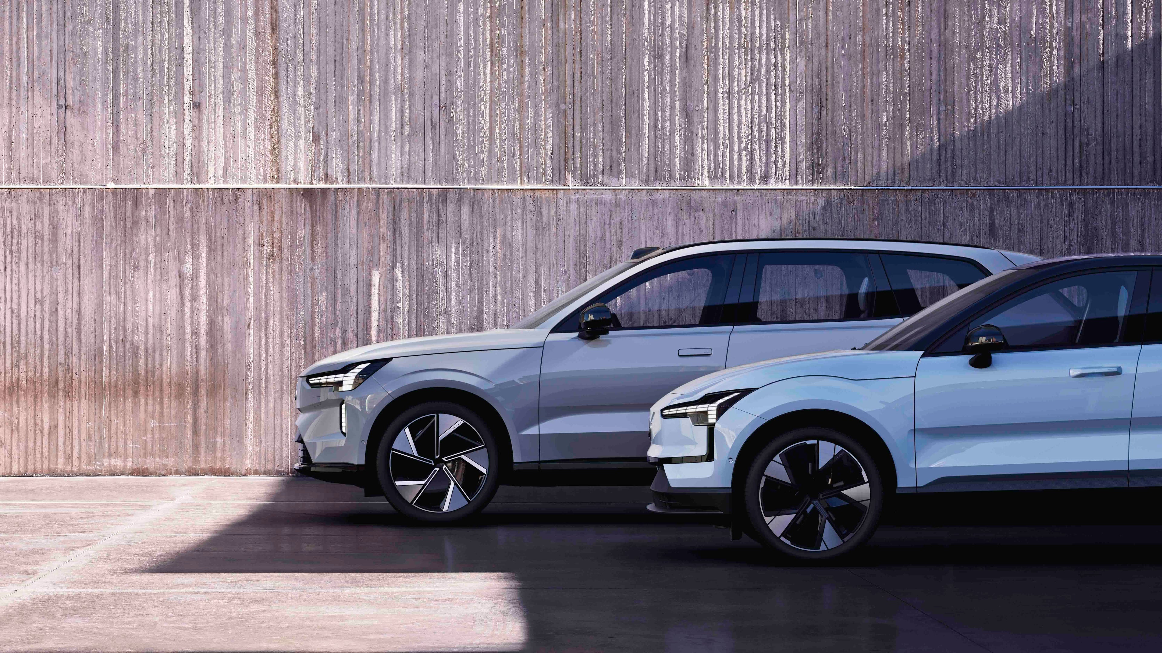 Dos vehículos Volvo en vista lateral parte delantera destacando sus faros LED y sus llantas.