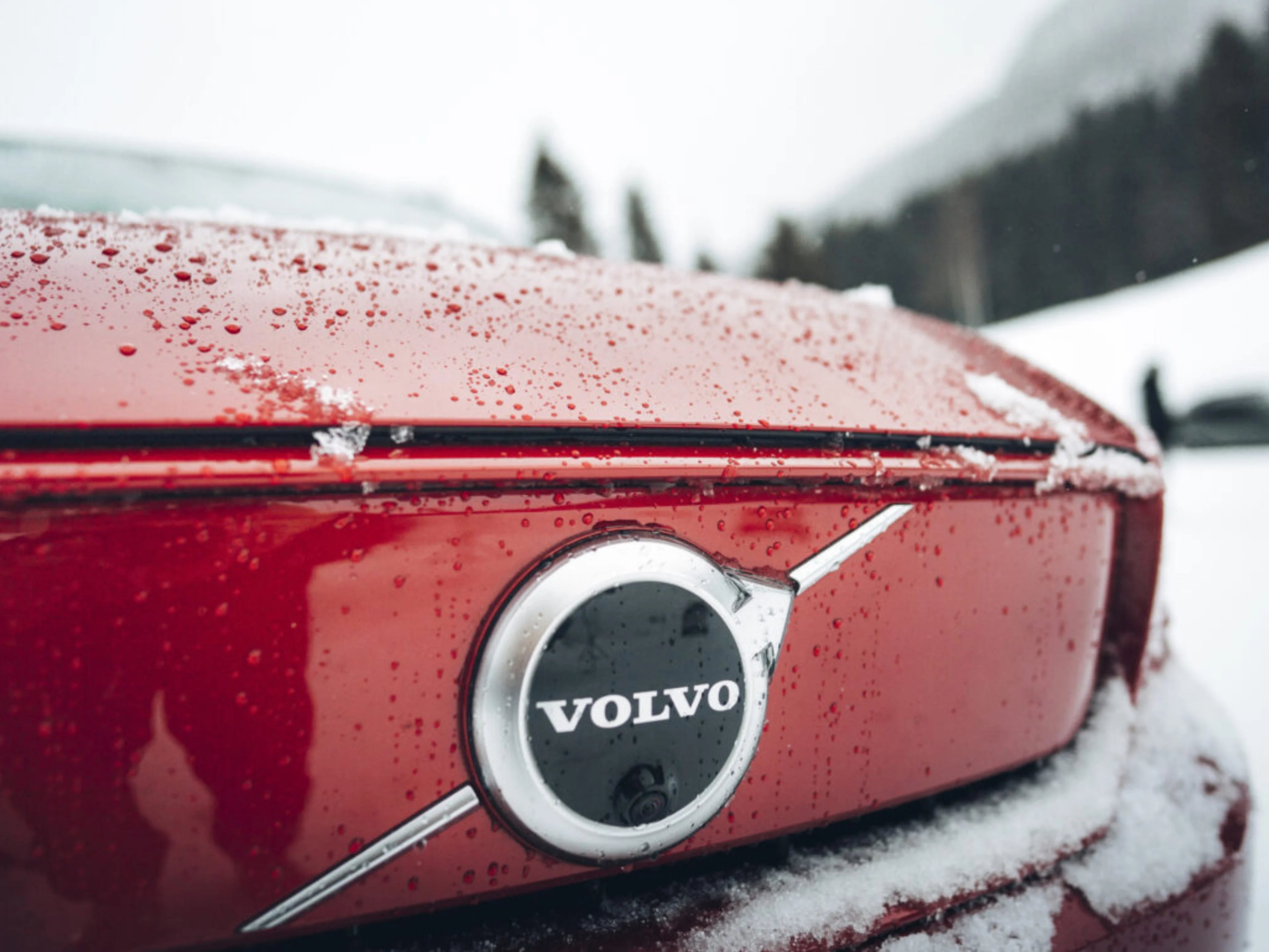 Primo piano del logo Volvo su una Volvo EX40 rossa.