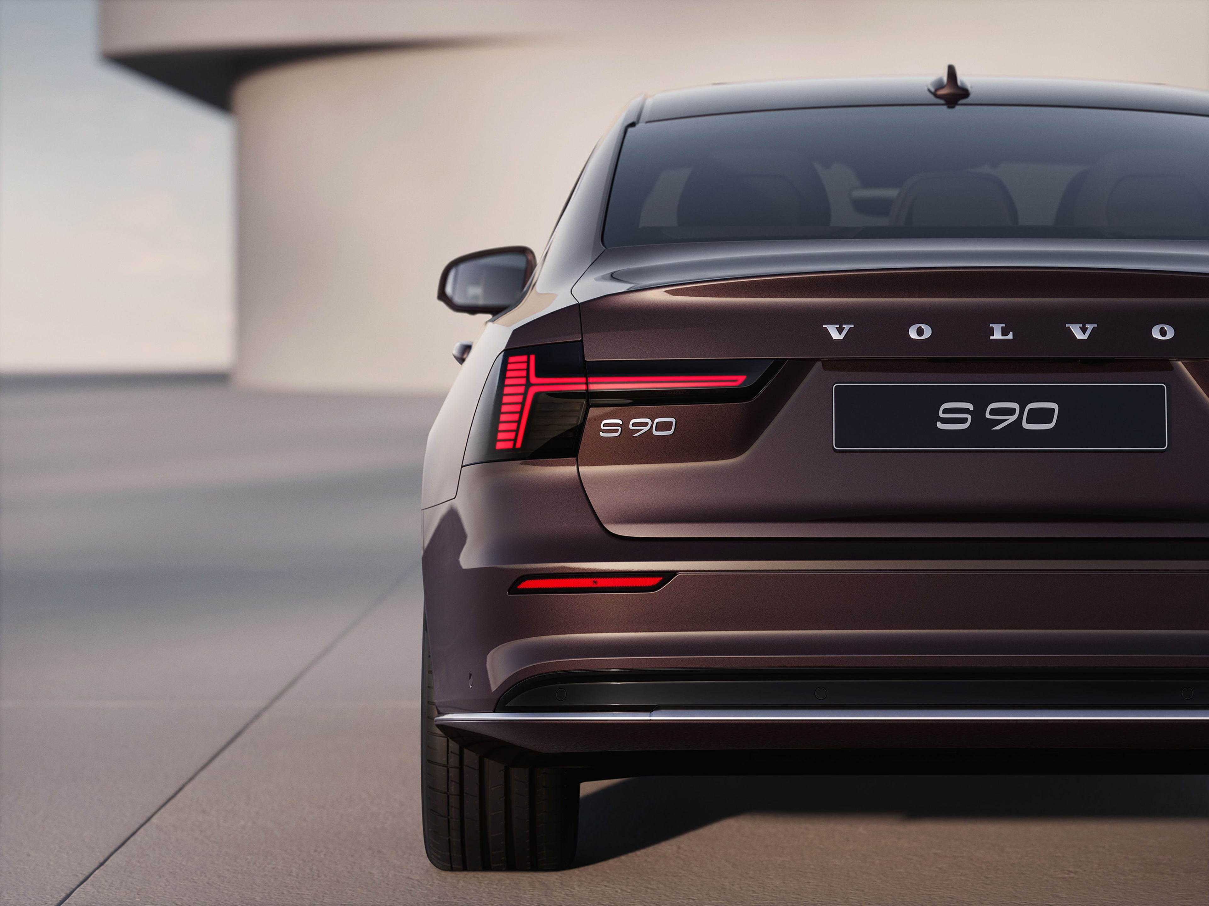 Back view of 2025 Volvo S90 plug in hybrid sedan with vertical LED taillights and Volvo badging.