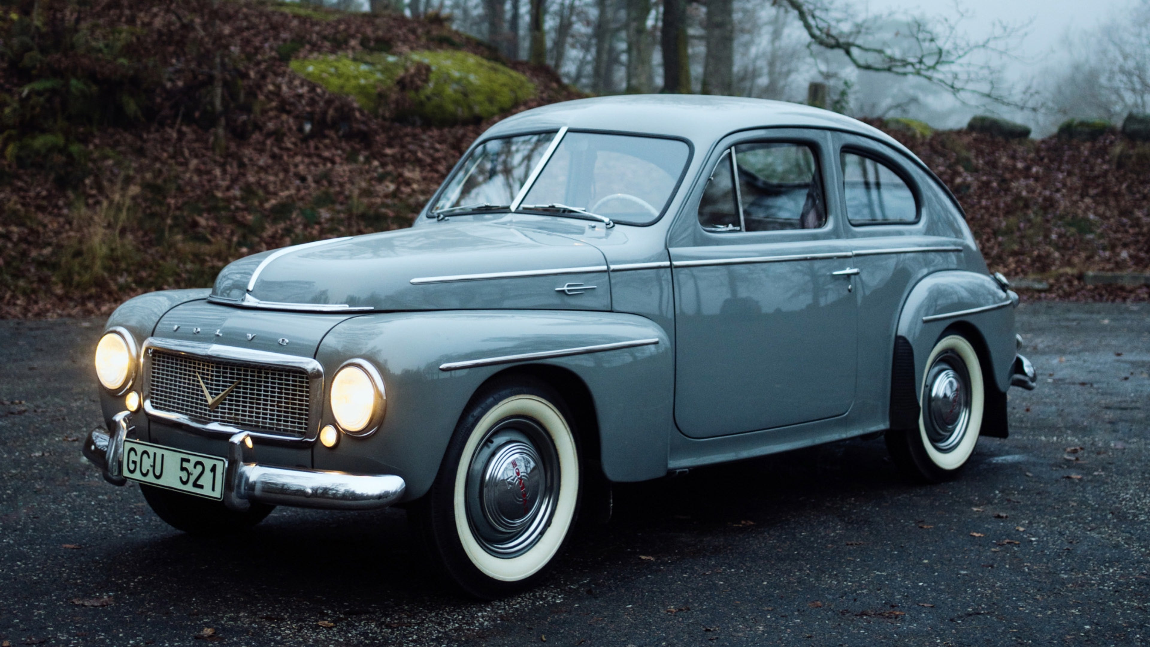 لقطة من الأمام لثلاثة أرباع Volvo PV444 الكلاسيكية، Volvo سويدية قديمة من خمسينيات القرن العشرين مع شبكة مميزة ورفارف منحنية.