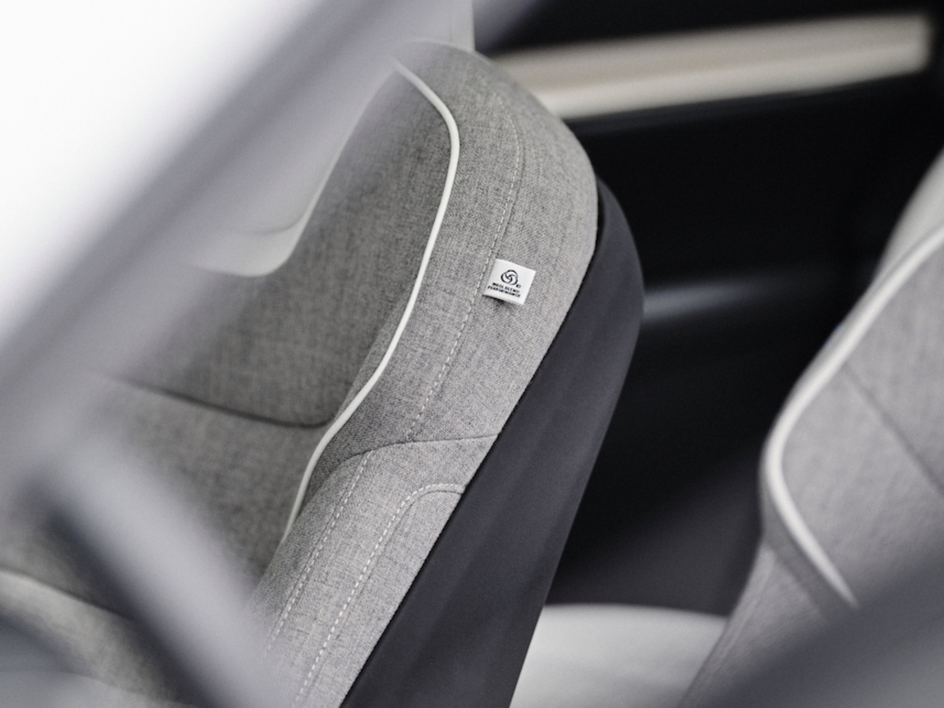 Graue Innenraumsitze mit Nachhaltigkeitszeichen.