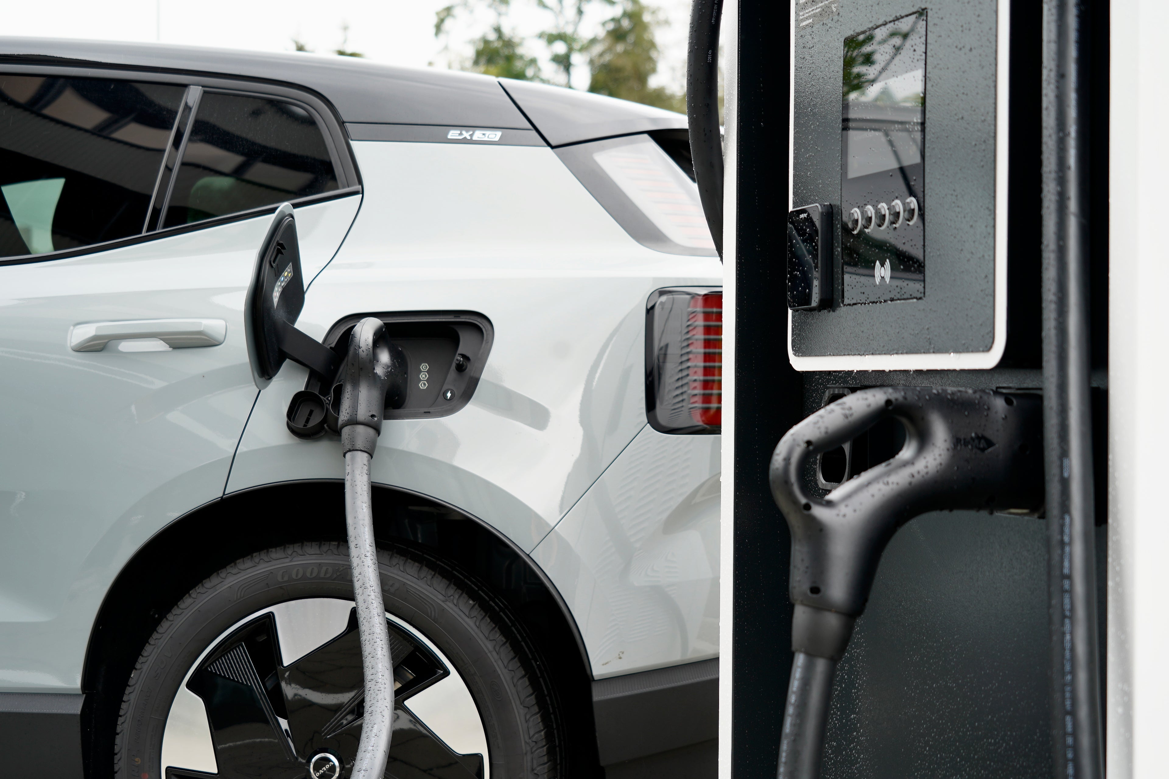 Borne de recharge Volvo sur laquelle une Volvo EX30 blanche est en train d'être rechargée.