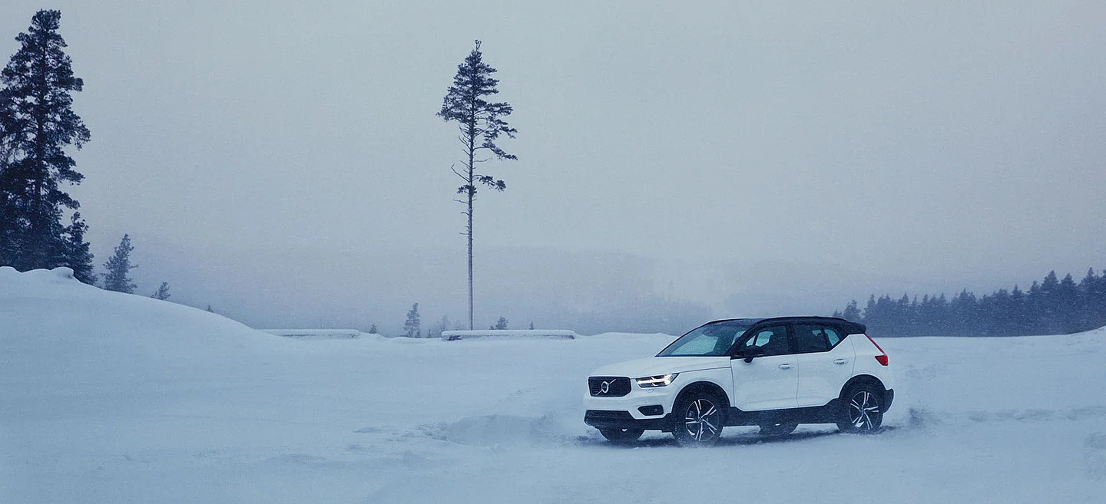 Ein weißer Volvo fährt im weißen Schnee