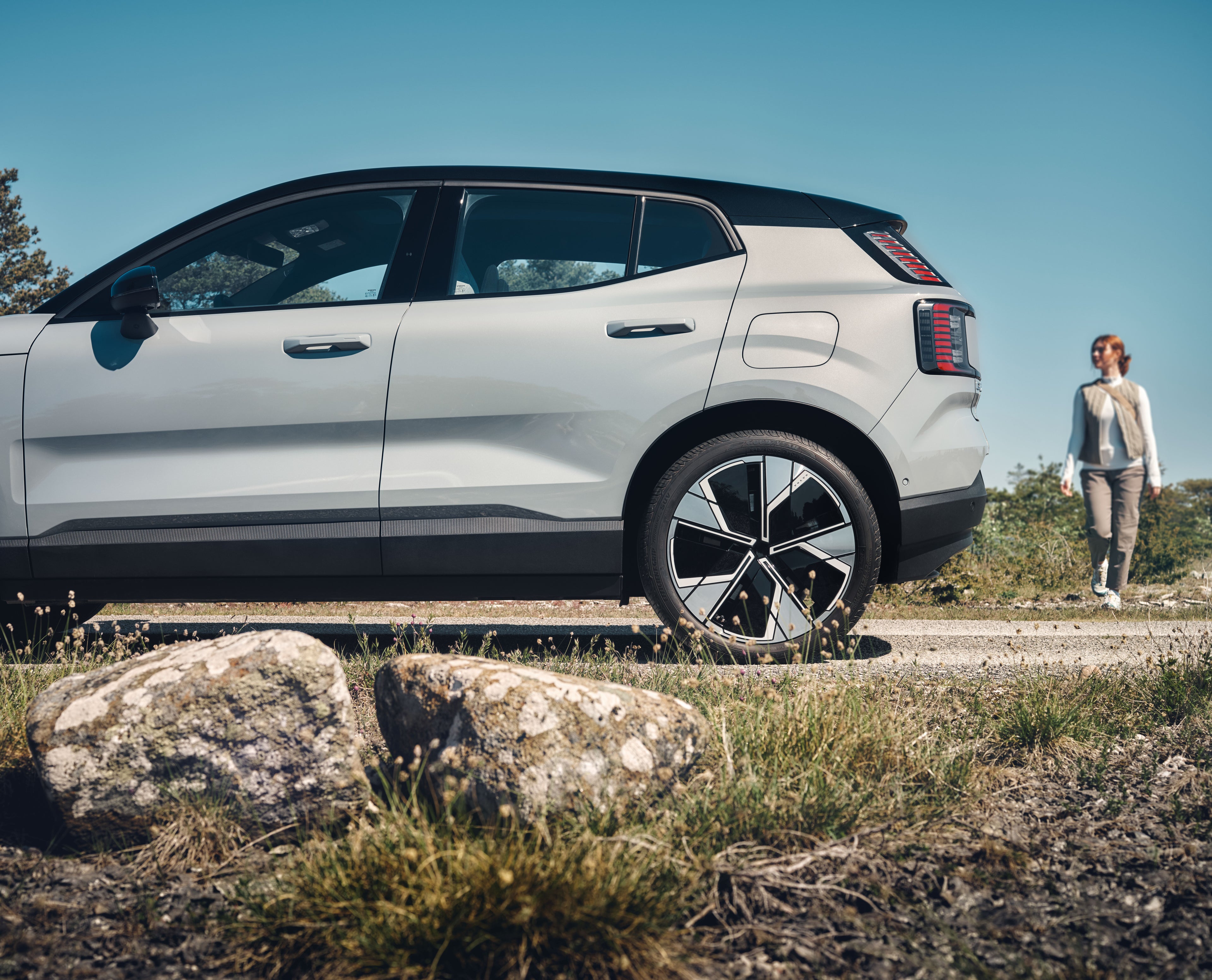 충전 코드를 Volvo EX90에 꽂고 있는 여성들 .