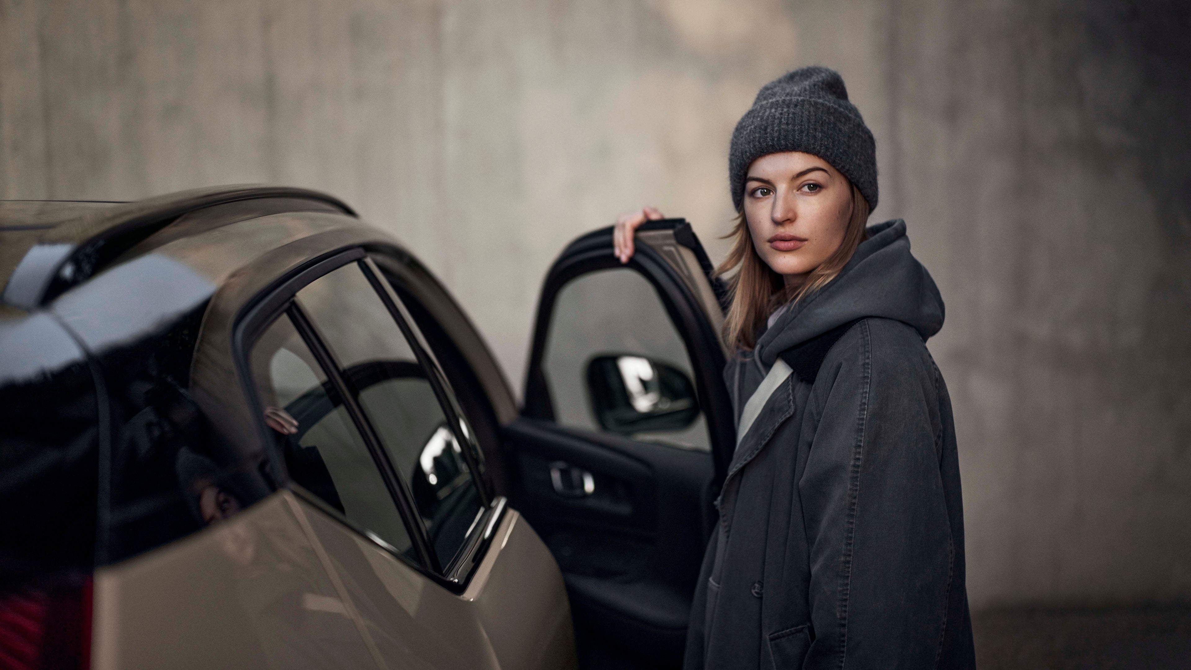 Una mujer abriendo la puerta de un vehículo Volvo