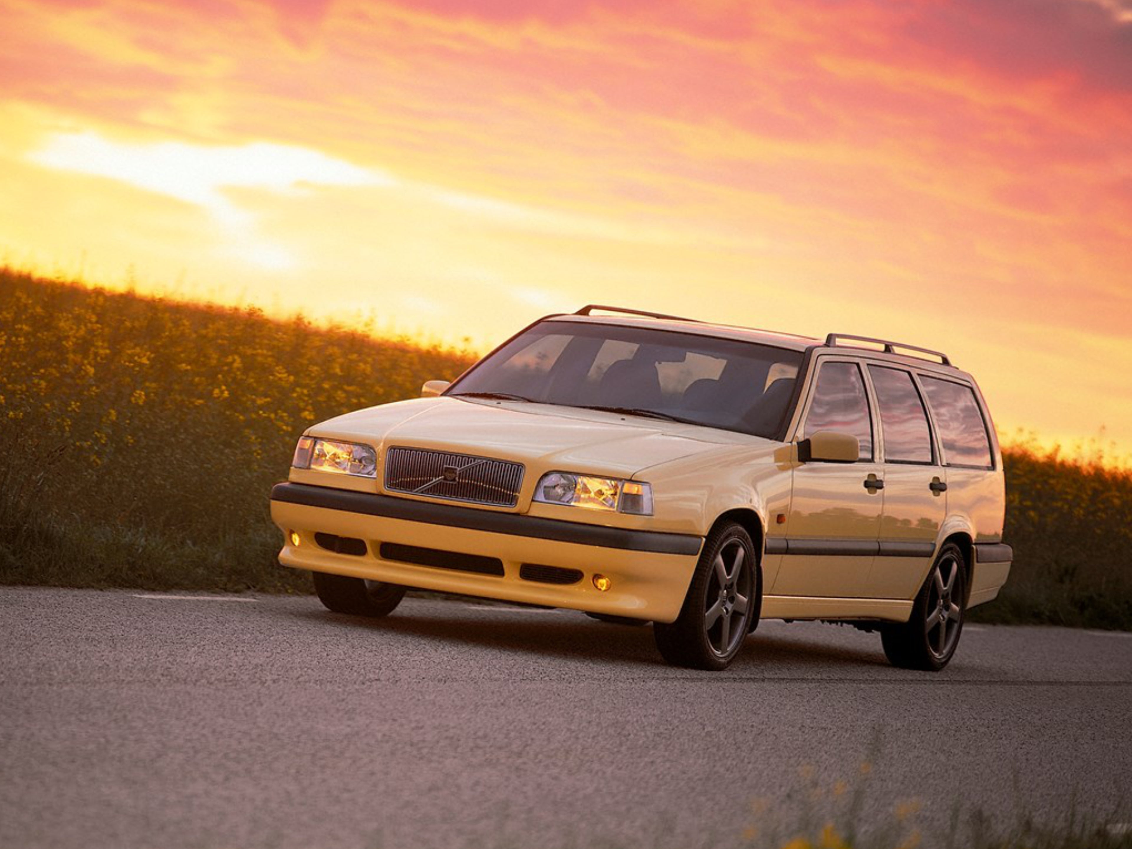 Volvo 850 T5-R in gelb steht bei Sonnenuntergang vor einer Wiese