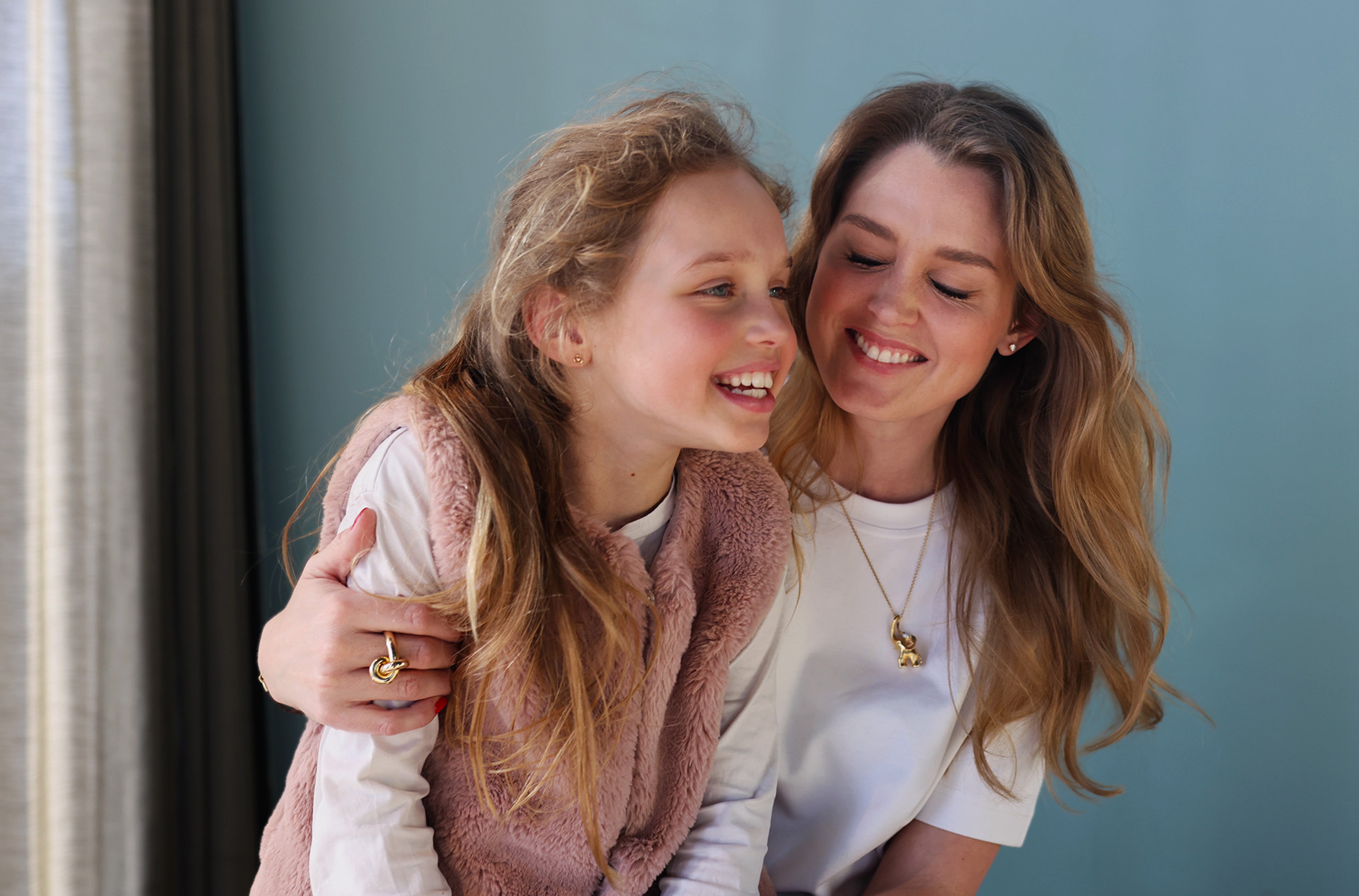 Мајка и ќерка се смеат заедно во топол, искрен портрет.