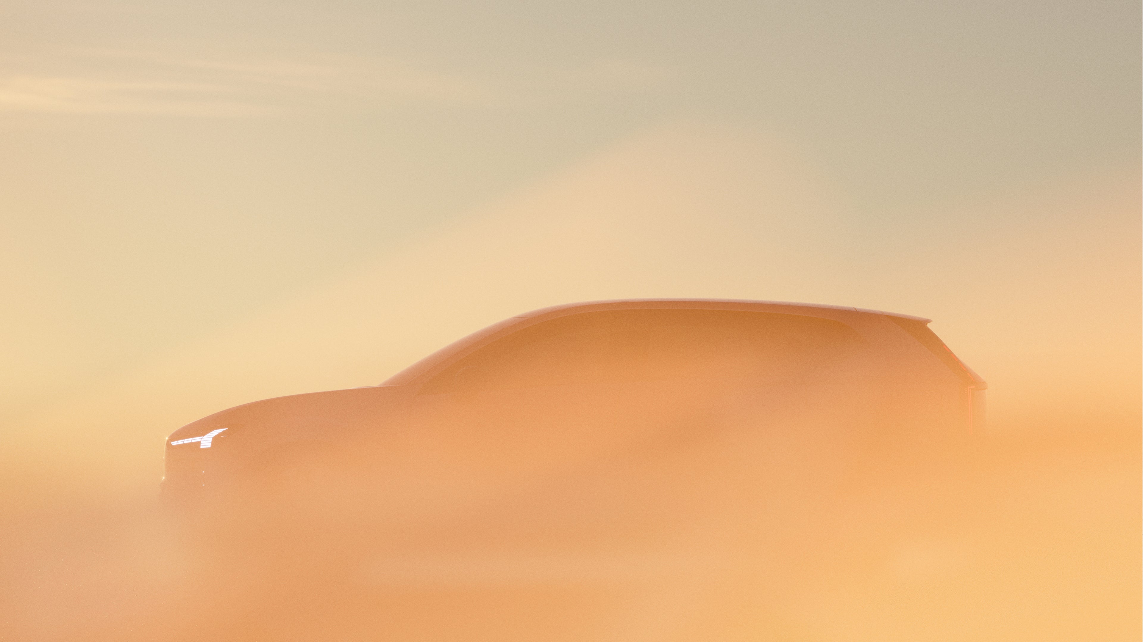 Контура на Volvo EX60 обвиткана во амбиентална портокалова магла.