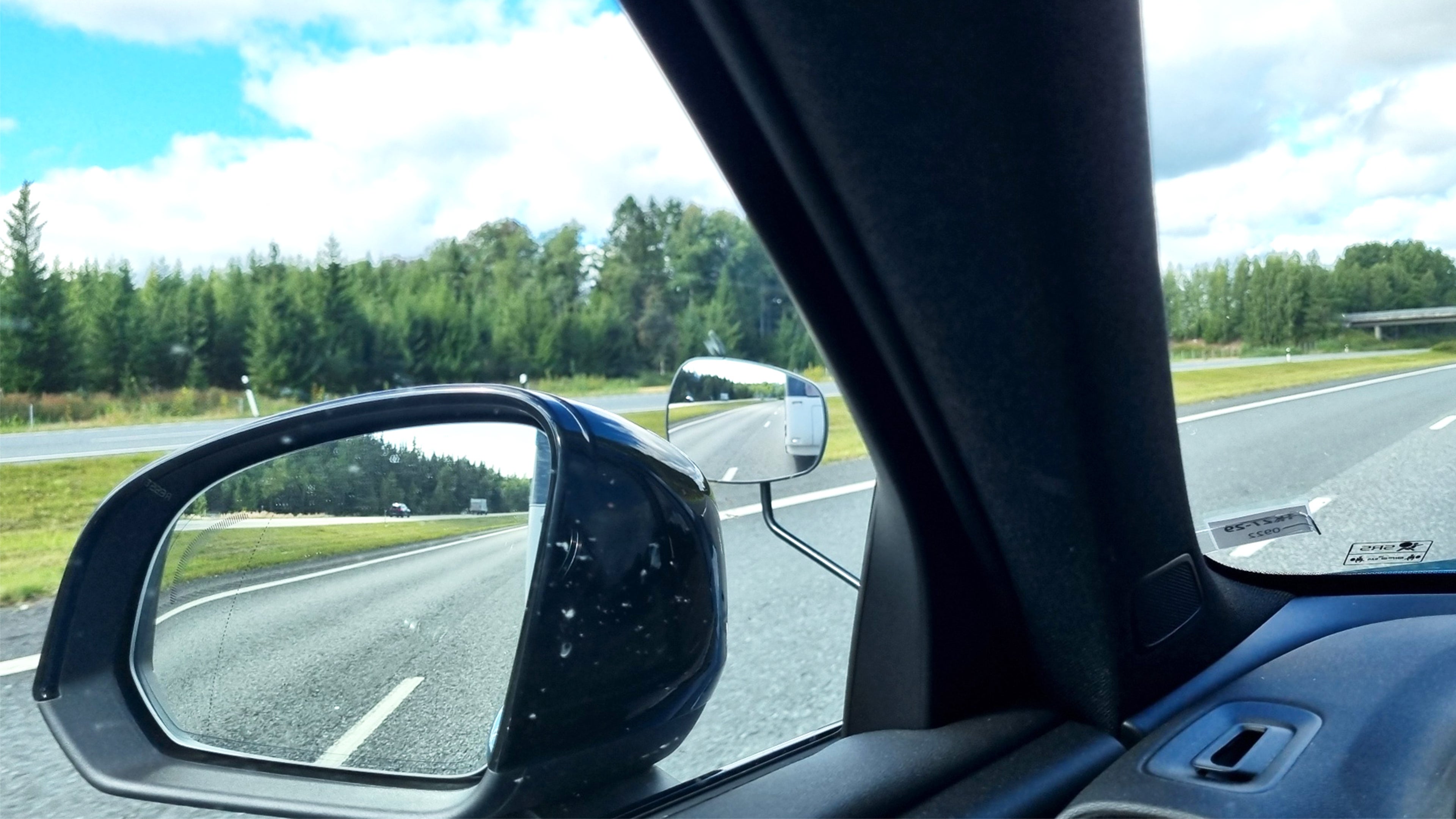 Lähikuva asuntovaunun vetoauton sivupeileistä. Asuntovaunu on havaittavissa lisäpeilissä.