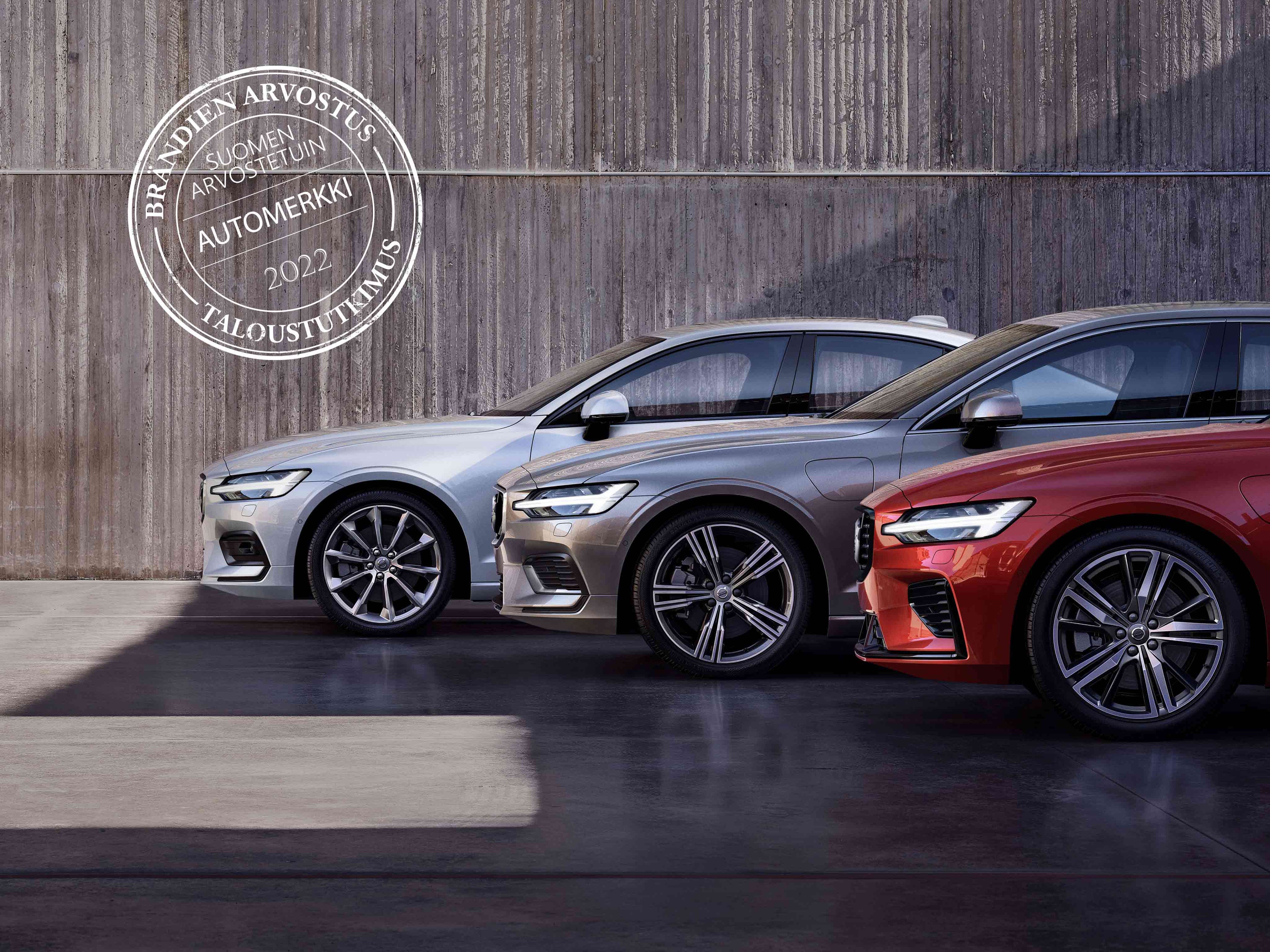 Three Volvo cars and the Suomen Arvostetuin Automerkki 2022 -logo.