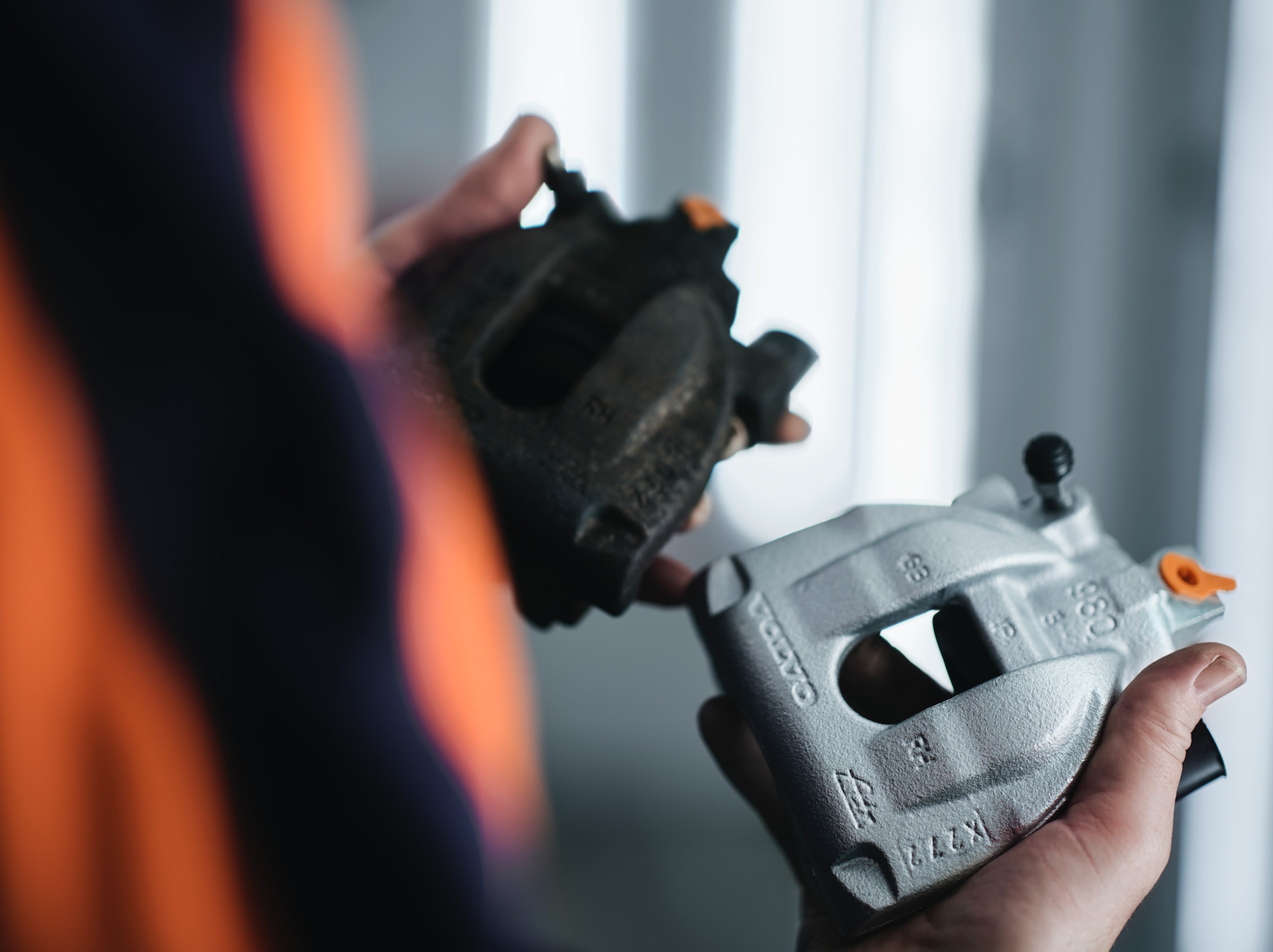 شخص في محطة التبادل في ماستريخت يحمل قطعة مستعملة من Volvo Cars في يد وقطعة مُعاد تصنيعها في اليد الأخرى.