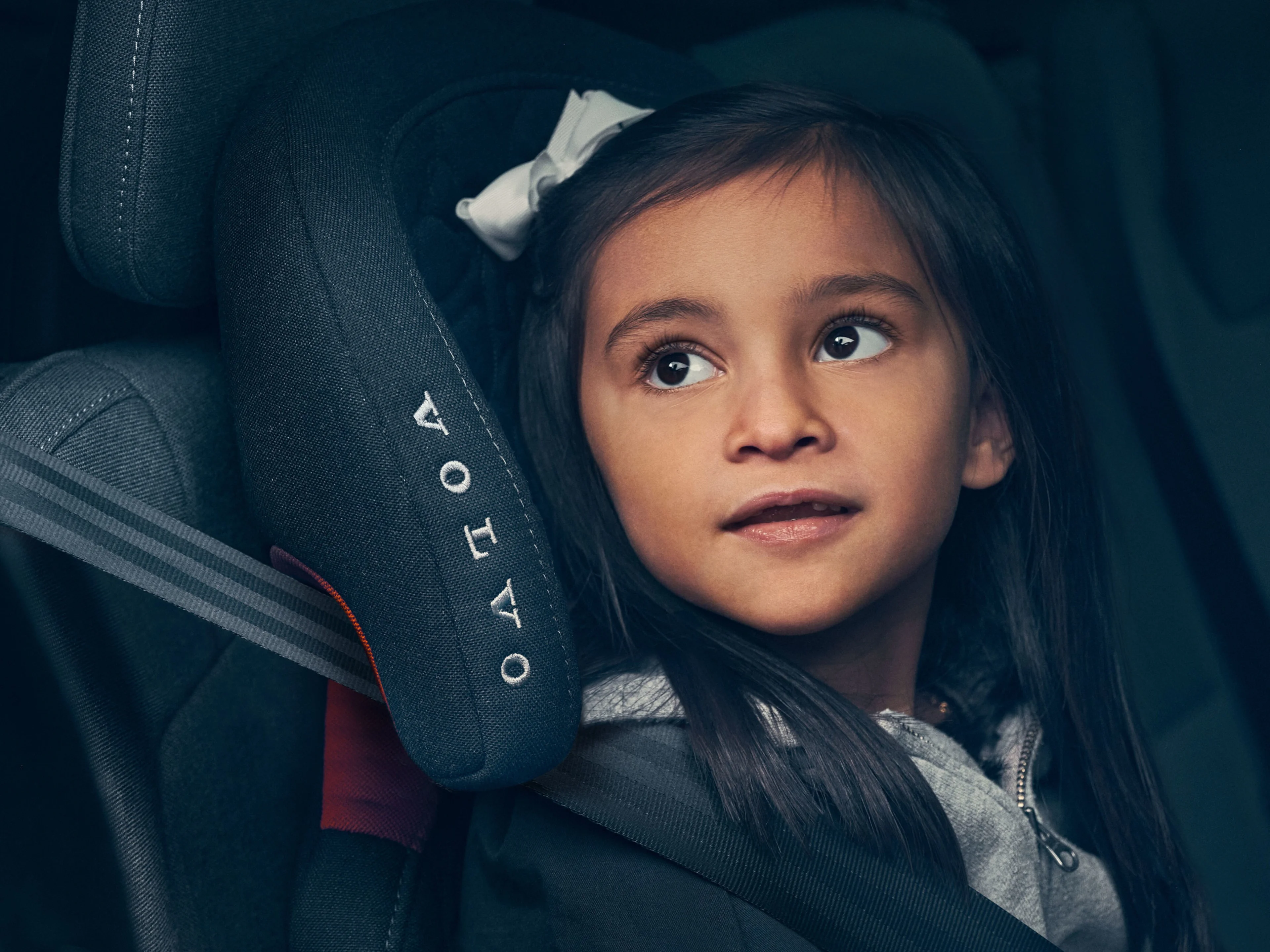 Holčička sedící v dětské sedačce Volvo