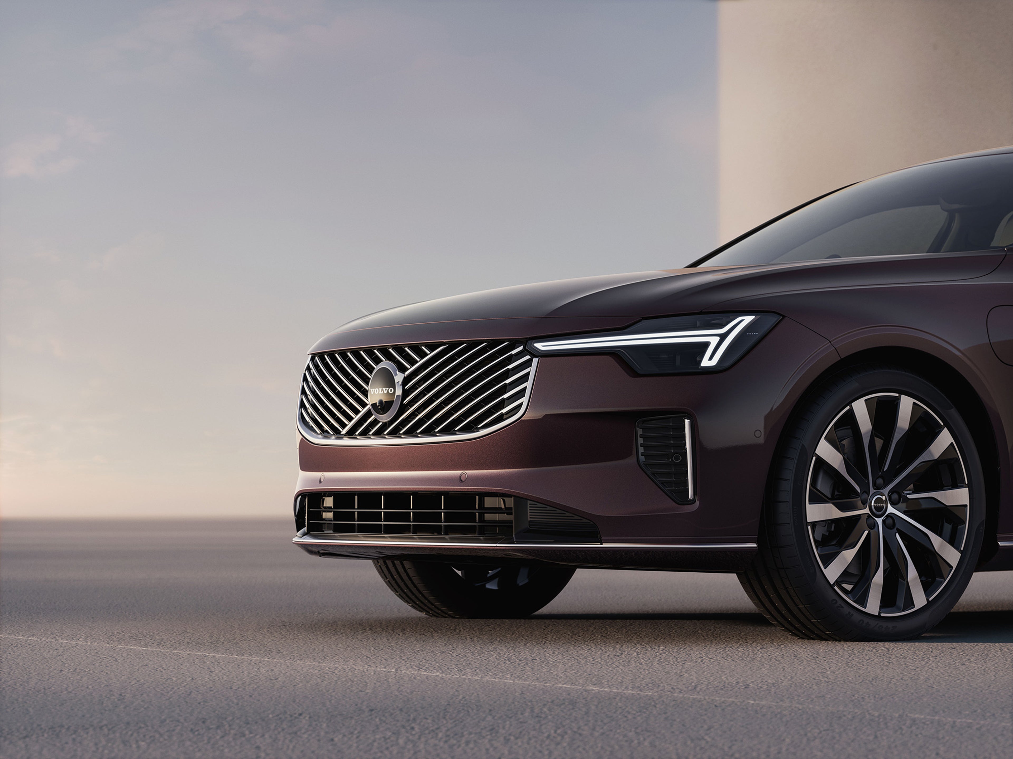 Close-up front view of the 2025 Volvo S90 plug in hybrid luxury sedan showcasing chrome grille and LED headlights.