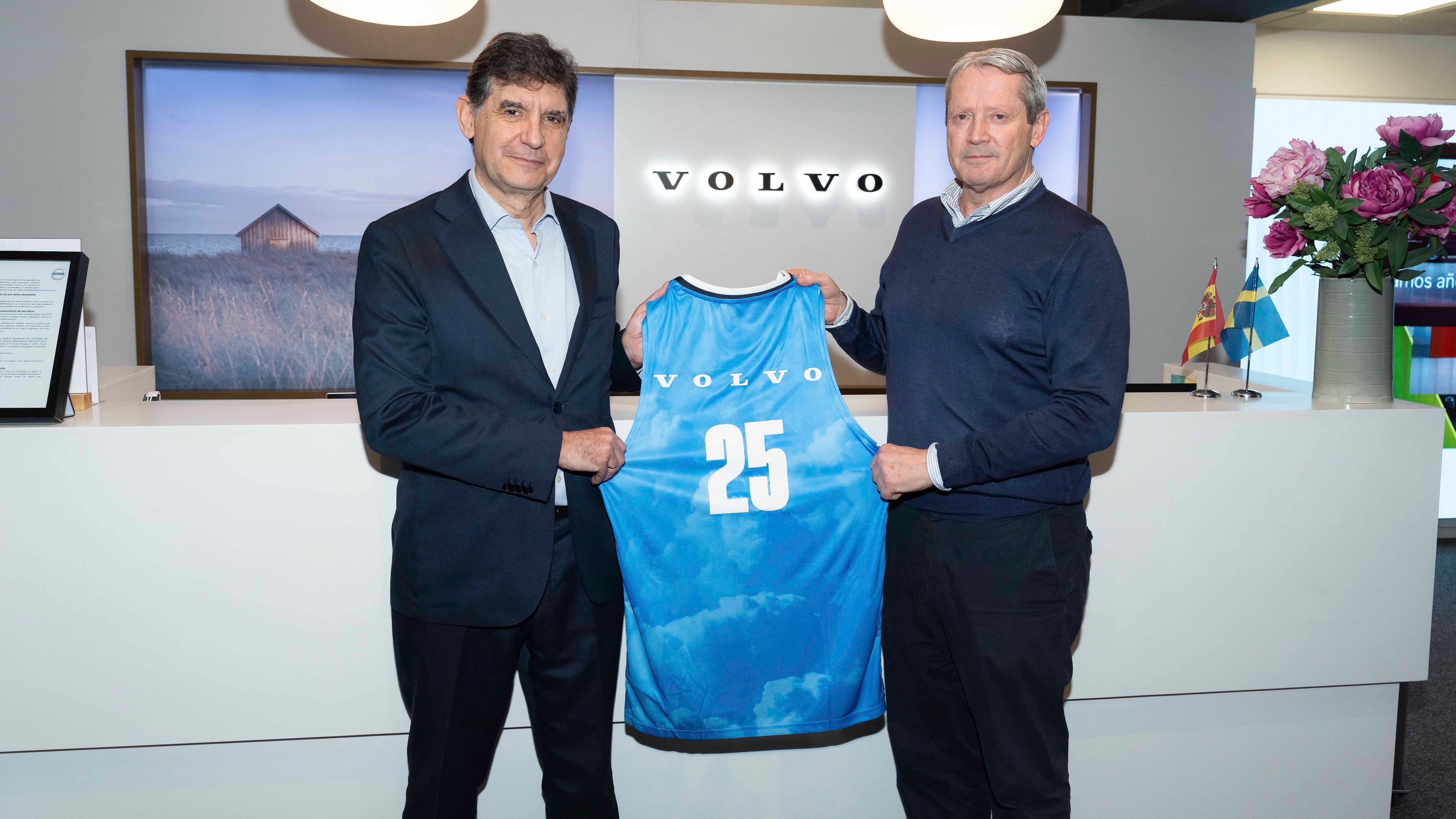 Dos directivos de compañía sujetando una camiseta de baloncesto