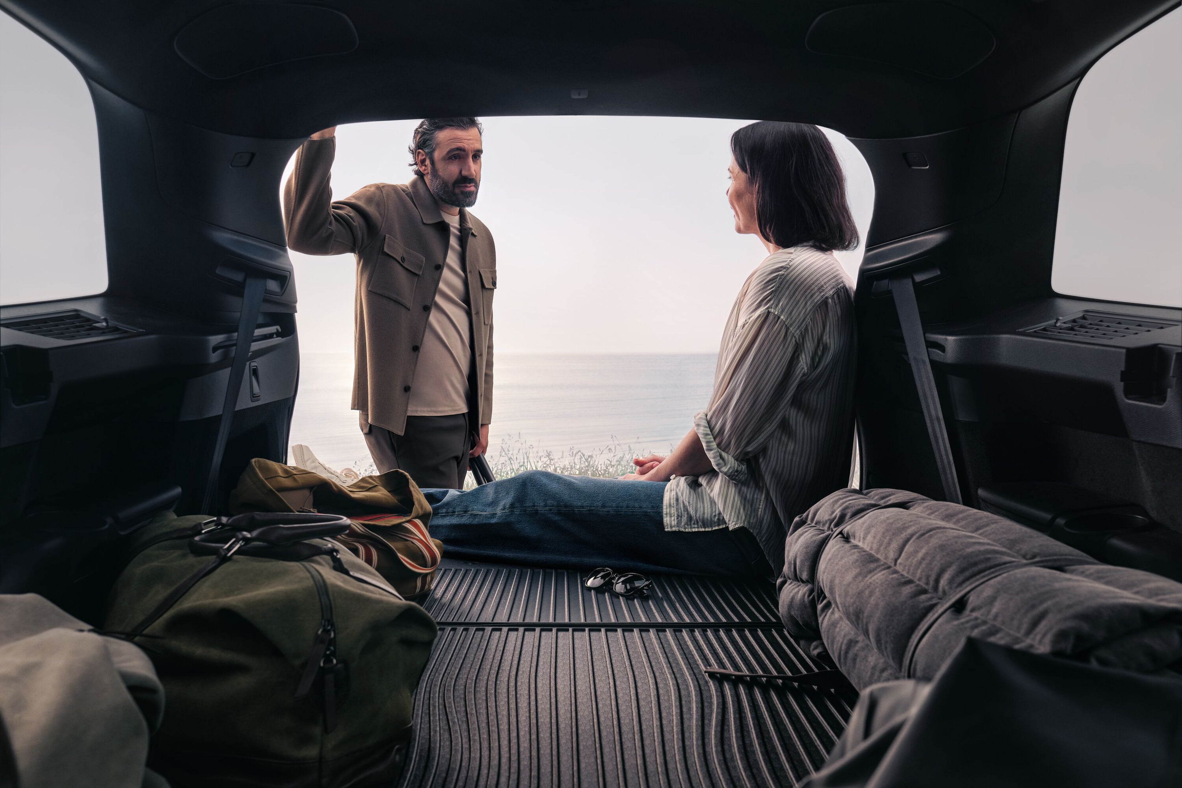 Muž so ženou konverzujú v zadnej časti vozidla XC90