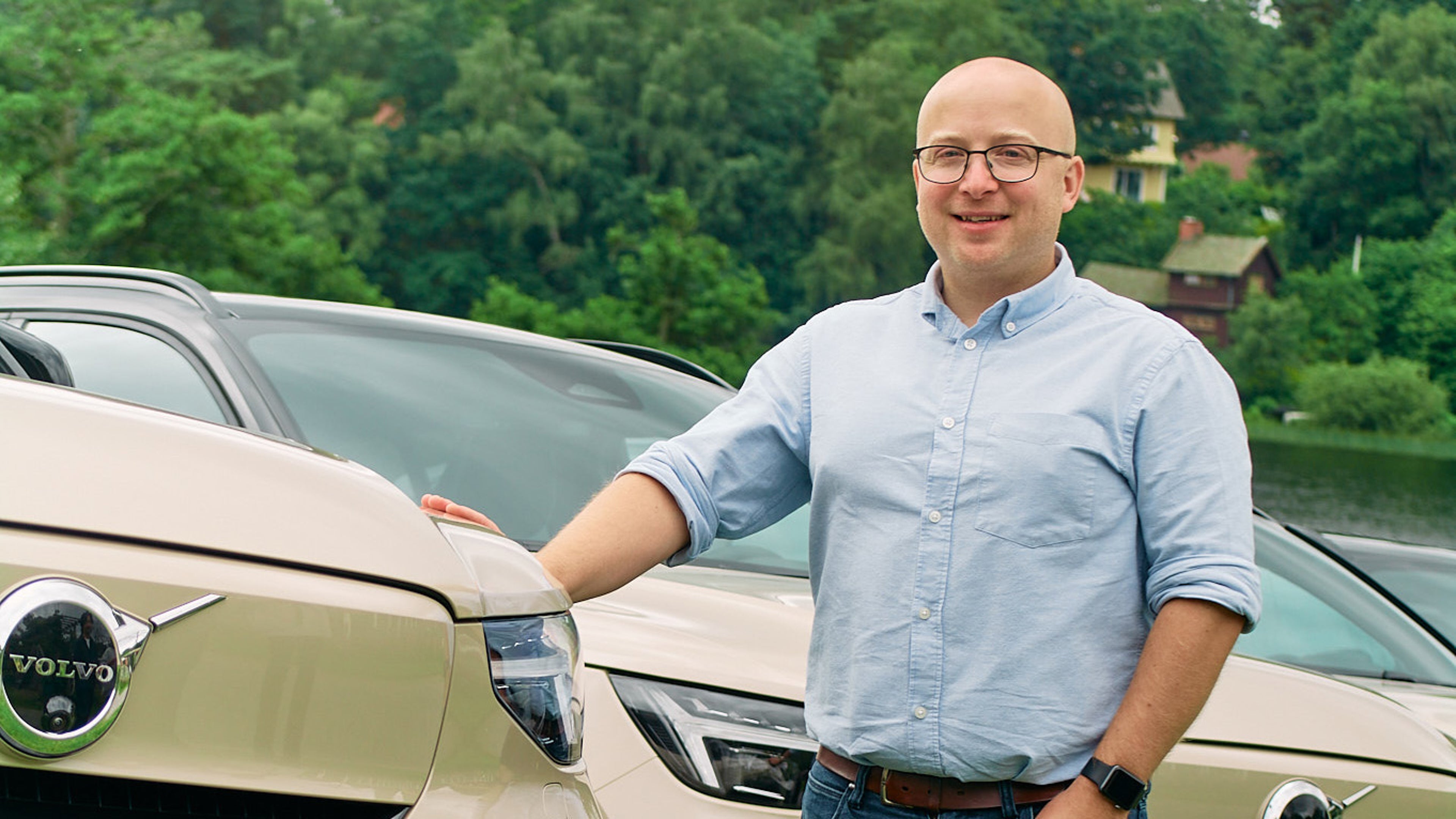 Owain Griffiths standing in front of a fleet of Volvo EX40 in sand dune color.