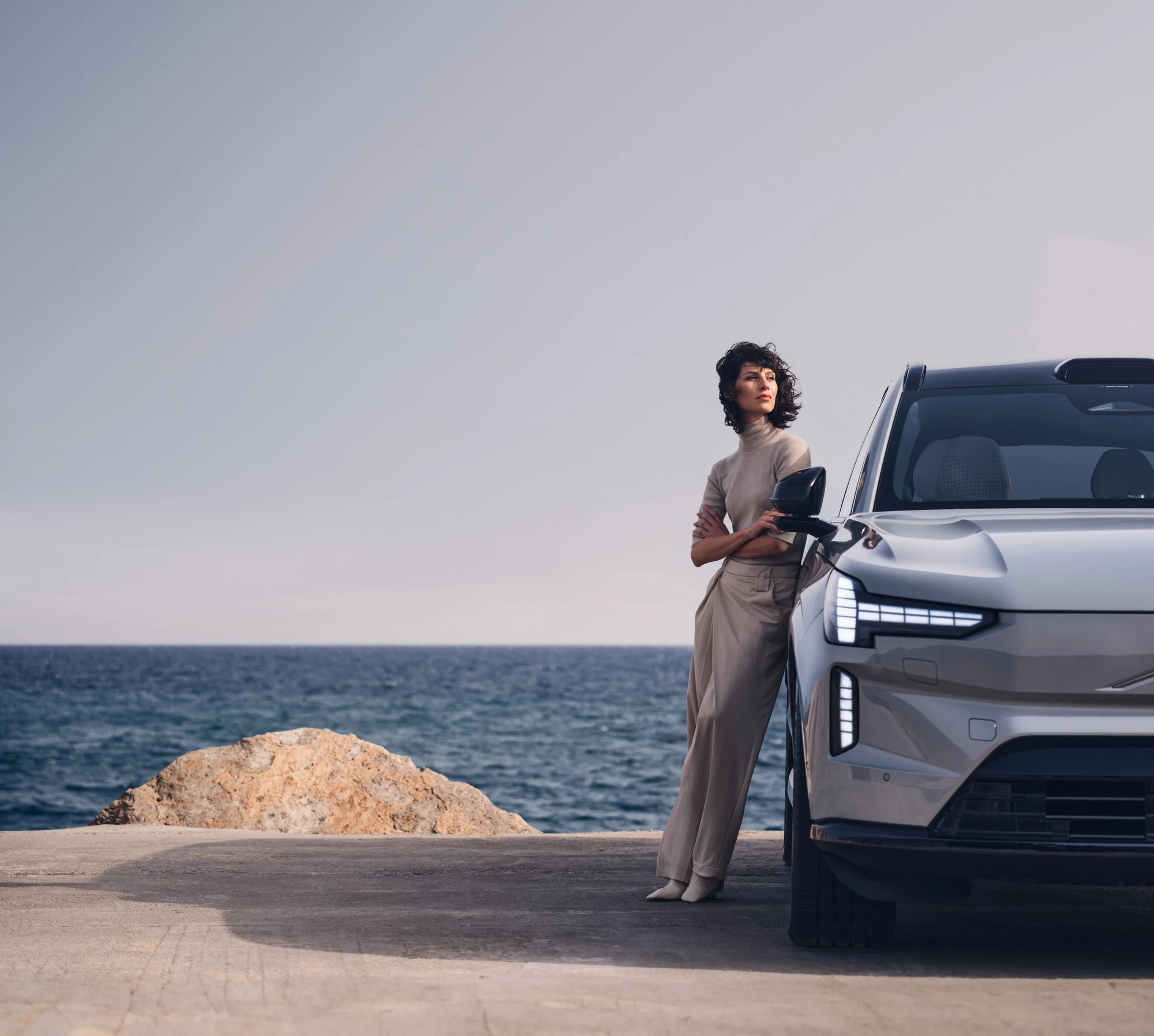 Egy nő áll egy Volvo EX90 előtt