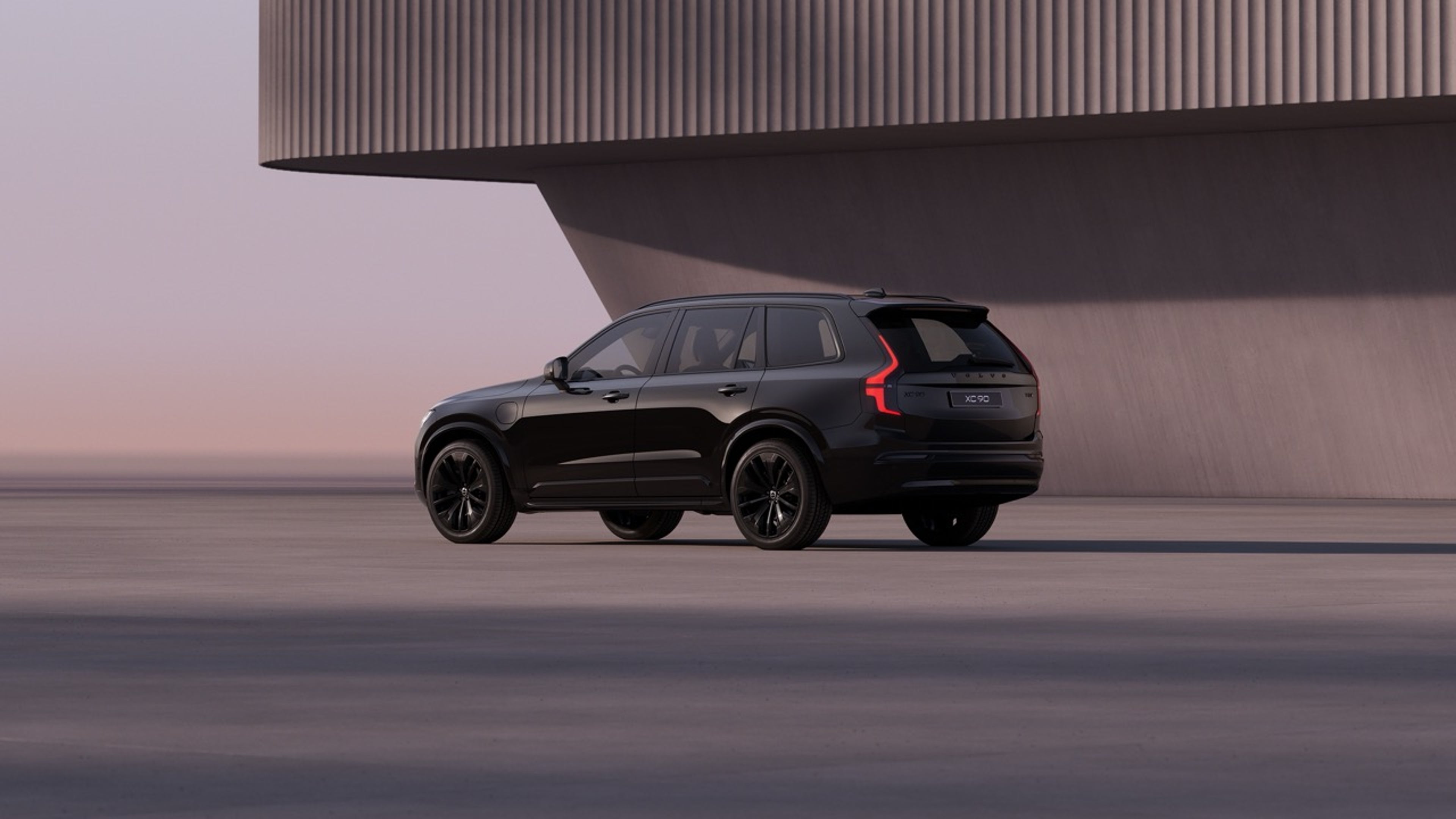 Back view of an all black Black Edition XC90 parked at sunset.
