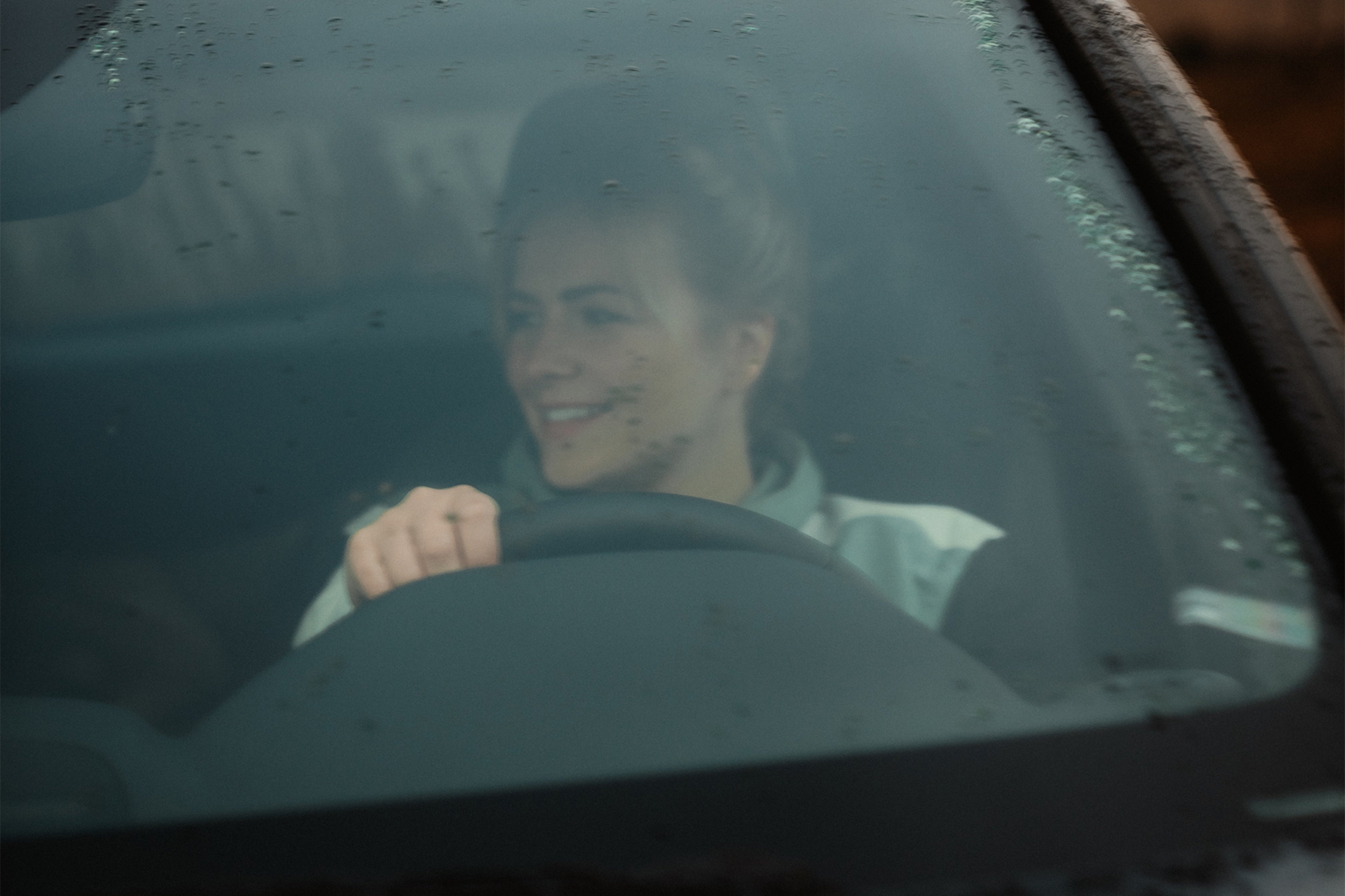 Laulaja Yona XC40 sähköauton ratissa.