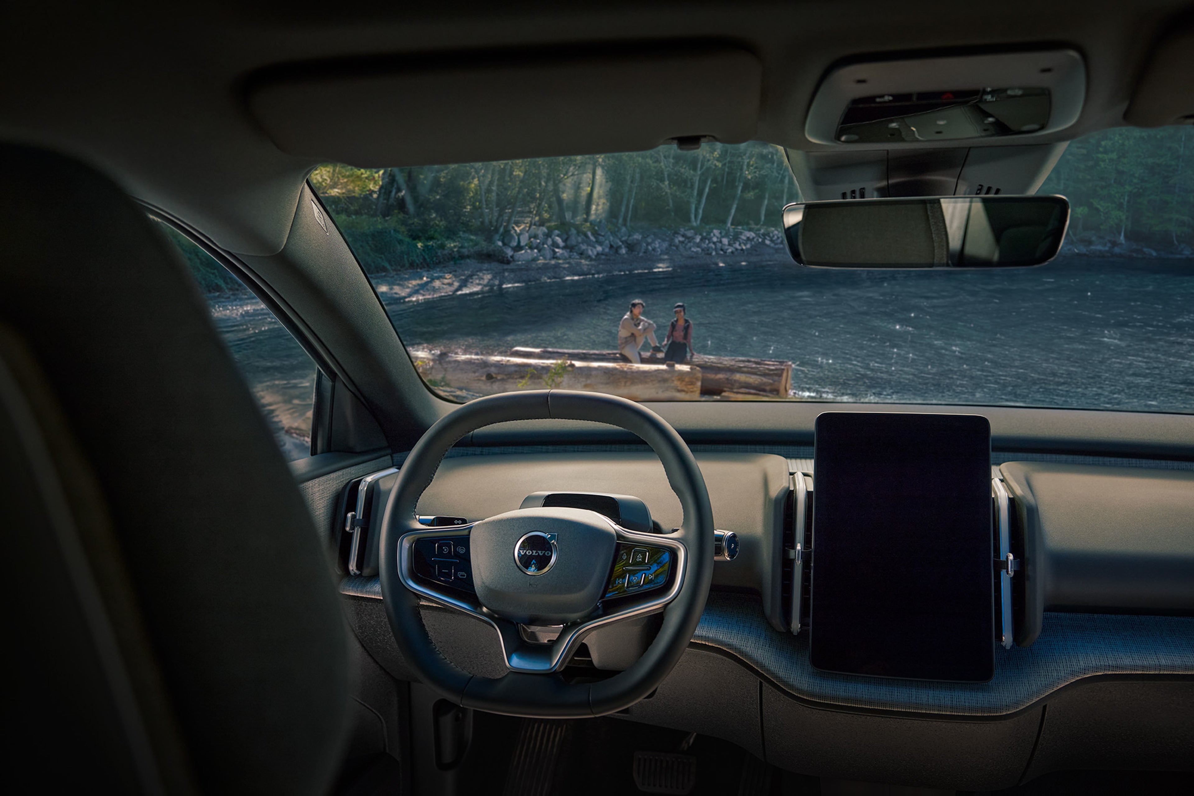 التصميم الداخلي الفسيح والحديث لـVolvo EX30 Cross Country، متوقفة على ضفاف بحيرة هادئة.