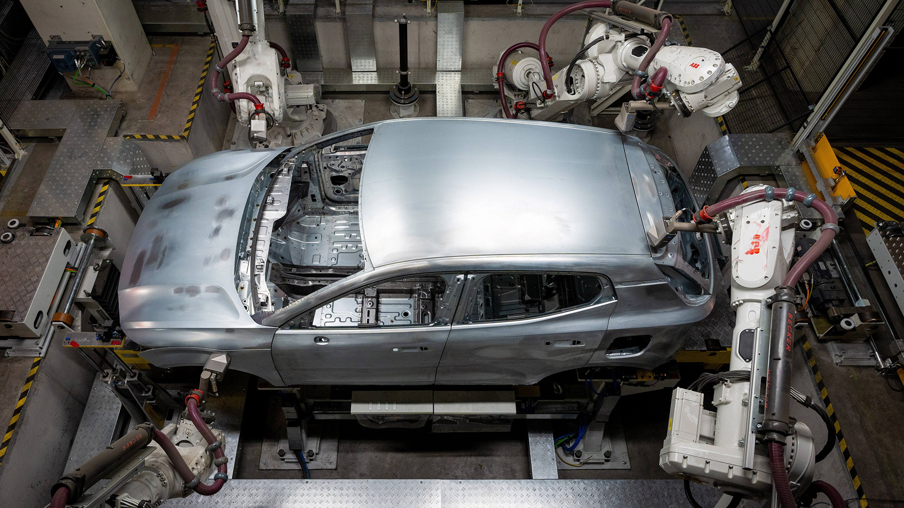 Volvo EX30 täyssähköauton kori robottien käsittelyssä Gentin tehtaan tuotantolinjalla.
