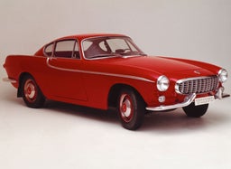 Volvo P1800 حمراء كلاسيكية مكشوفة مركونة في ساحة.