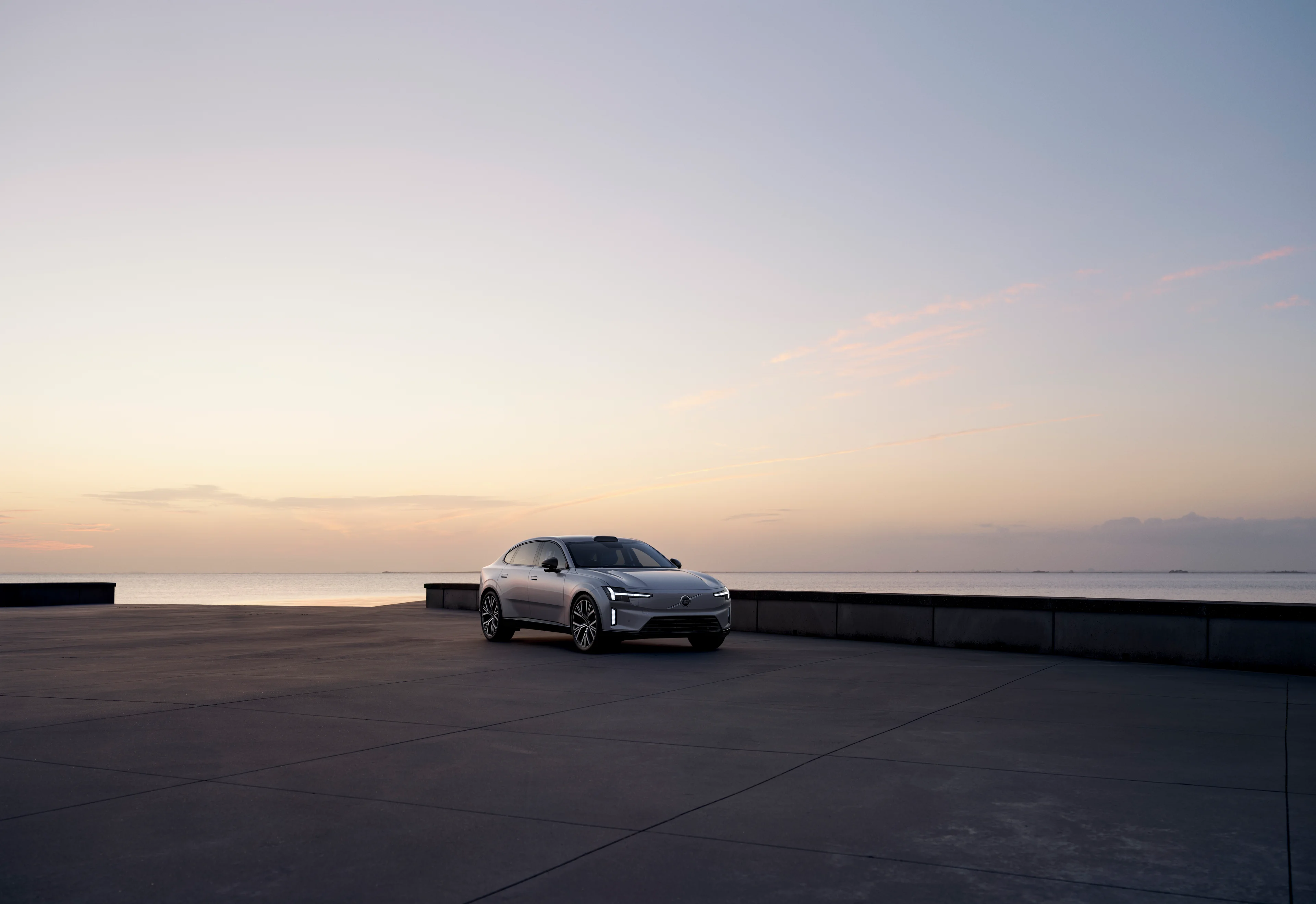 Vista lateral de um Volvo ES90 totalmente elétrico estacionado exibindo sua silhueta distinta.