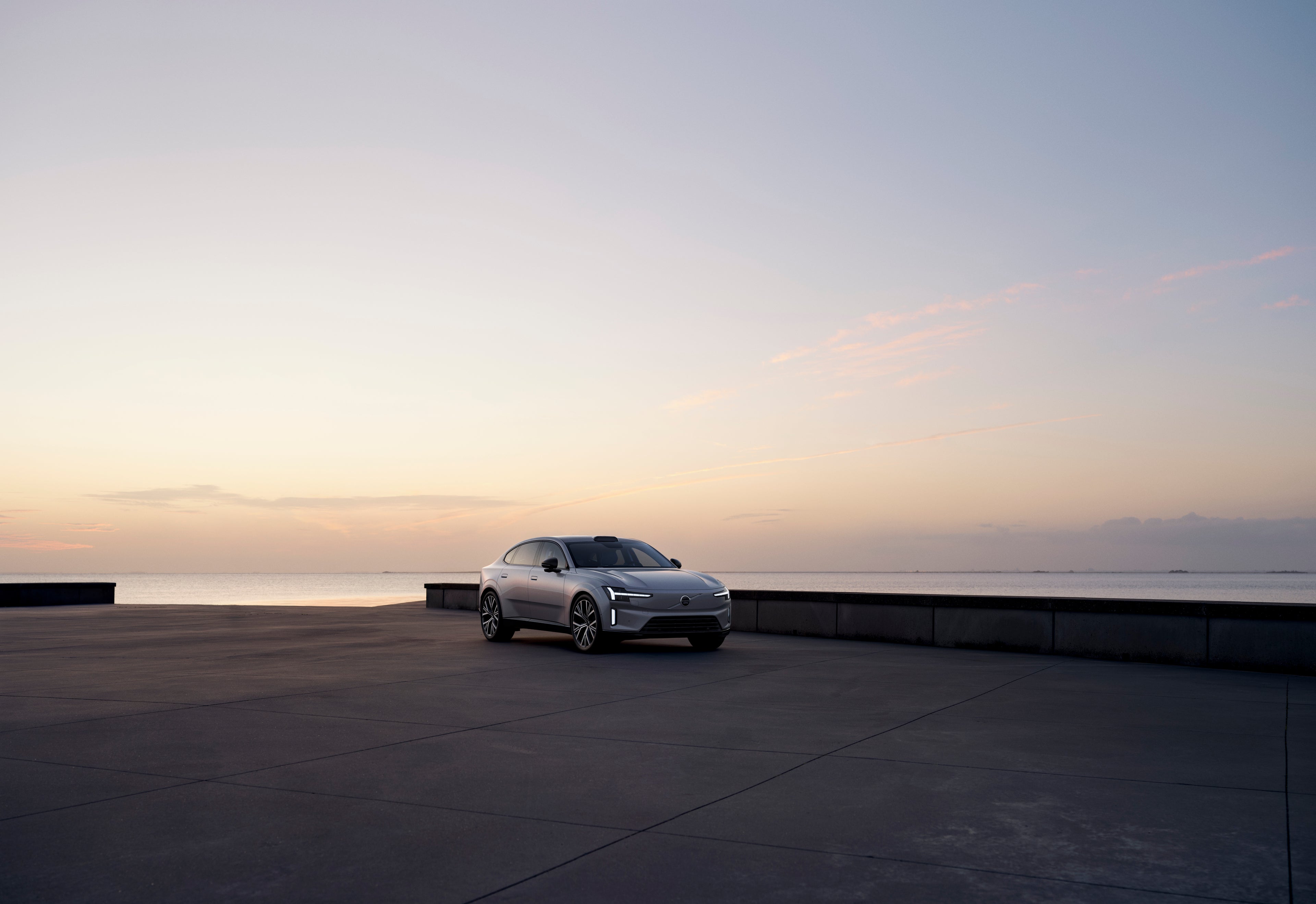 Vista lateral de um Volvo ES90 totalmente elétrico estacionado exibindo sua silhueta distinta.