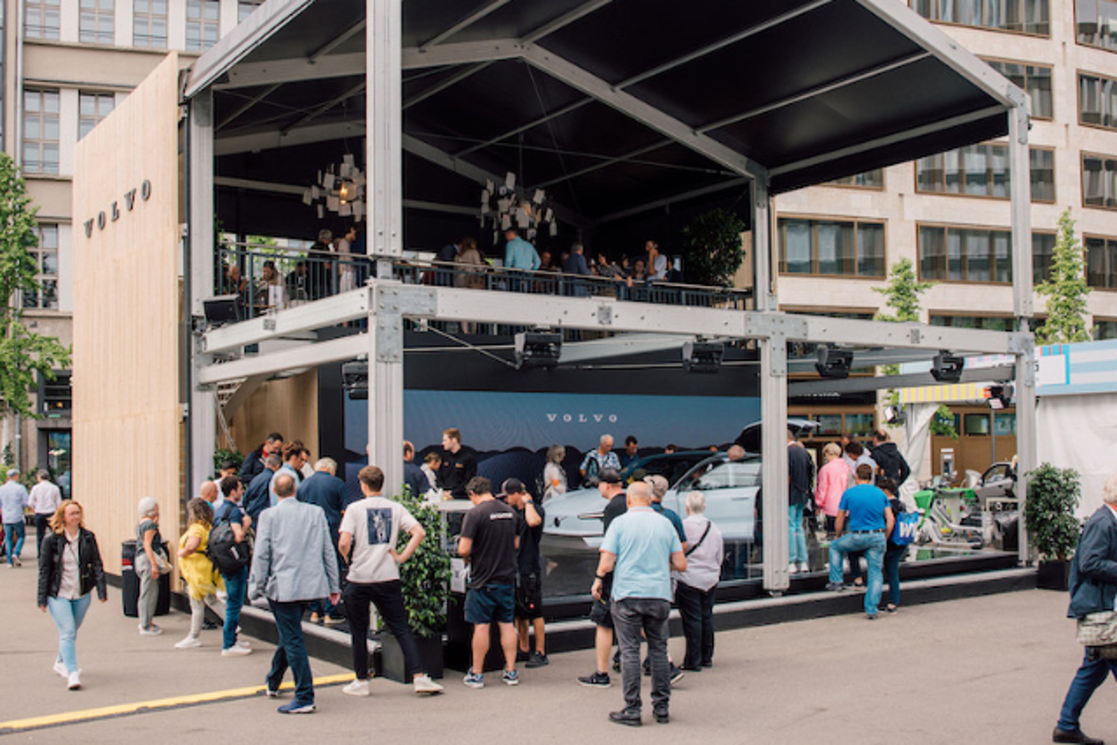 Persone riunite intorno a una Volvo EX90.