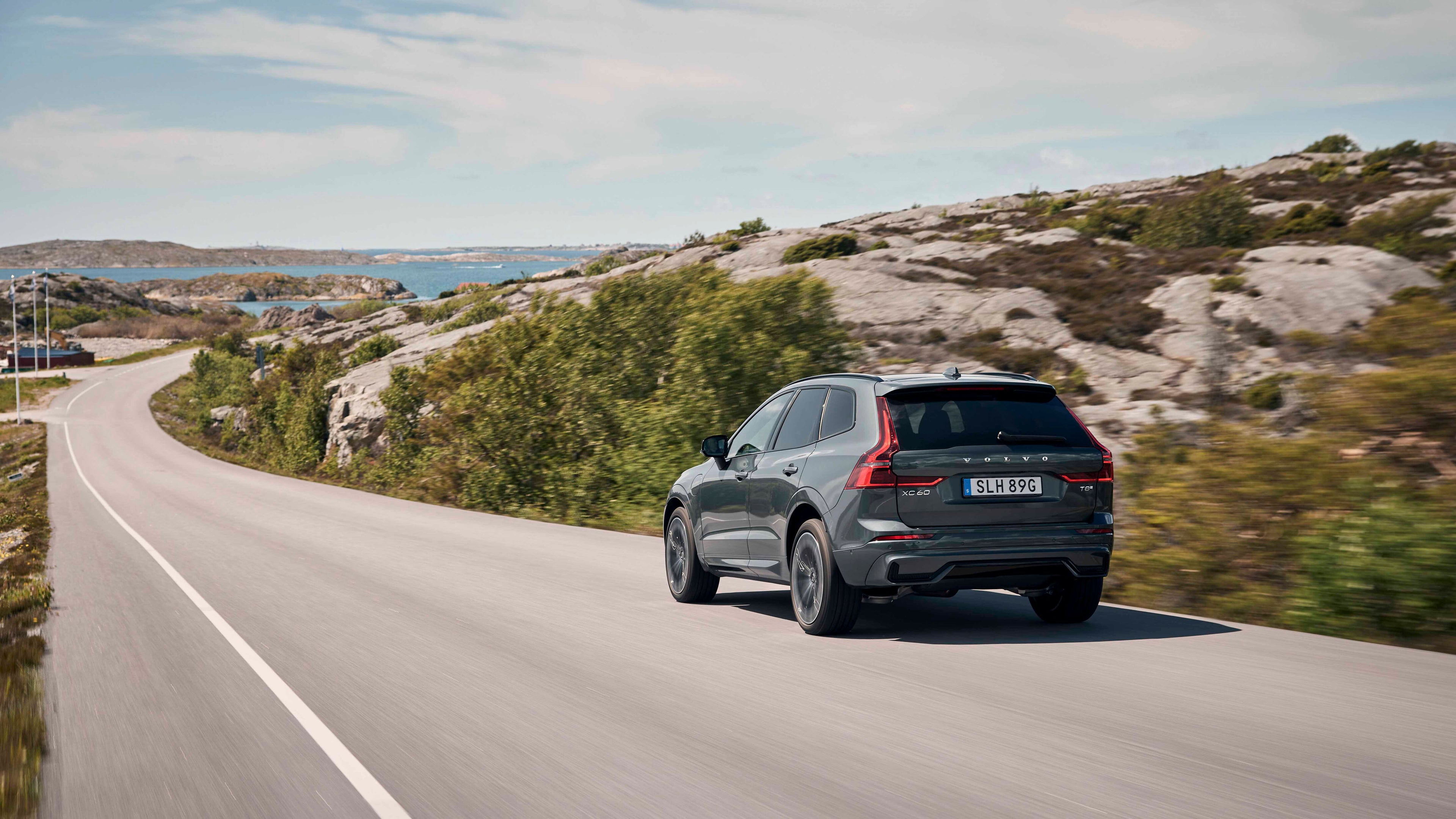 Volvo XC60 SUV circulando por una carretera junto al mar un día soleado