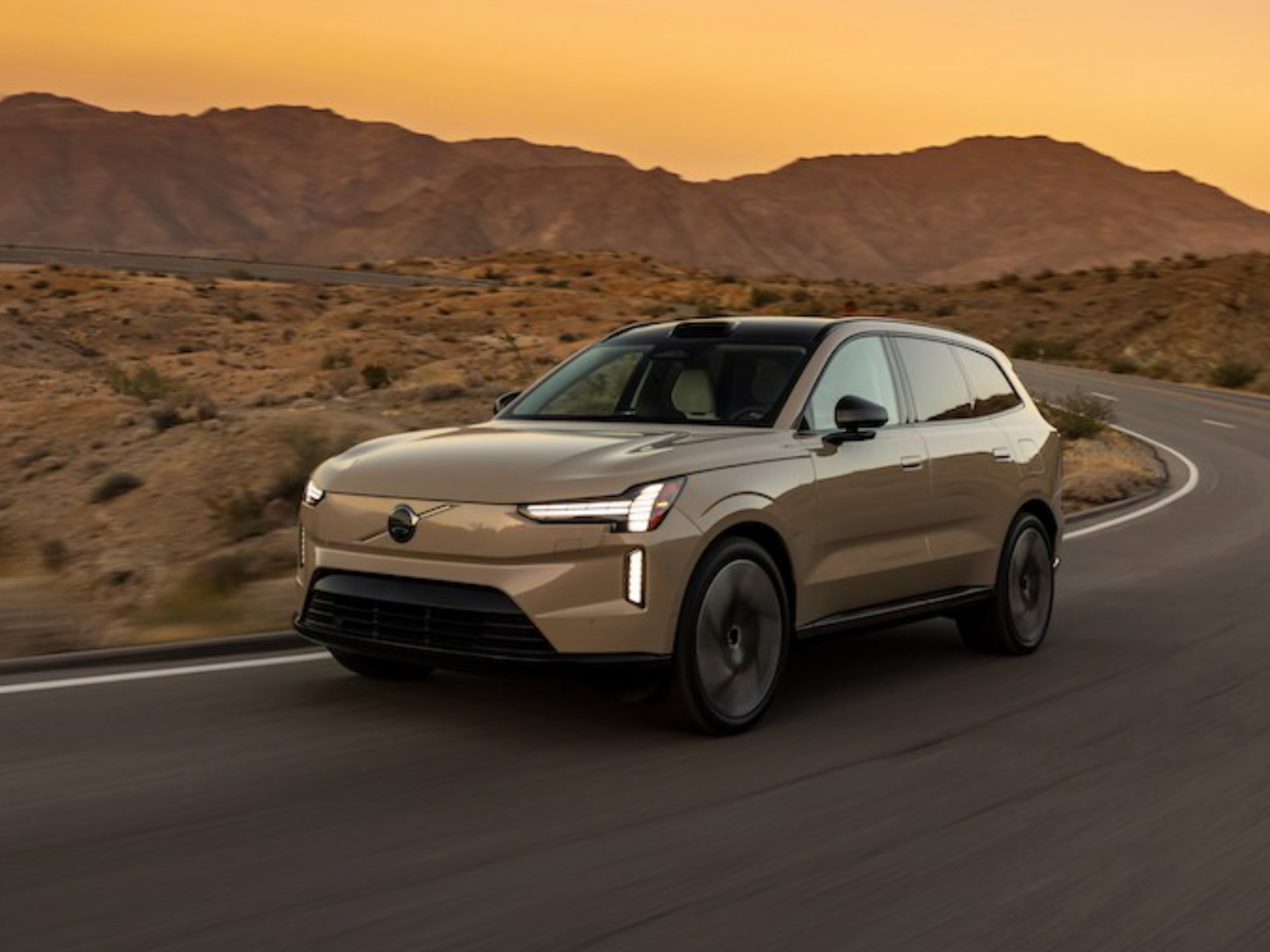 Vista laterale di un Volvo EX90 che affronta una curva della strada.