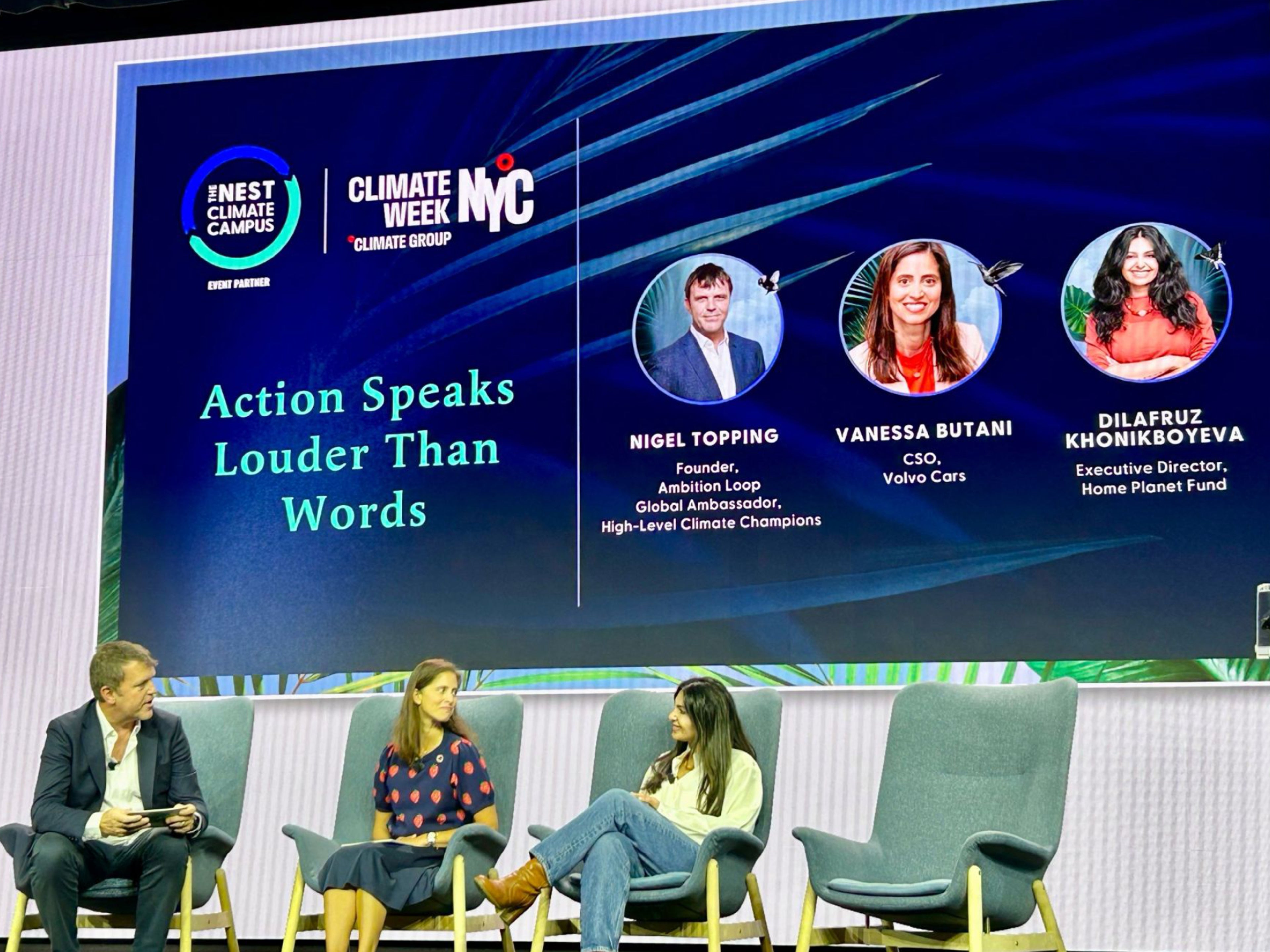 Aufnahme der "Climate Week"-Talkrunde, bestehend aus einem Mann und zwei Frauen, die sich auf einer Bühne unterhalten.